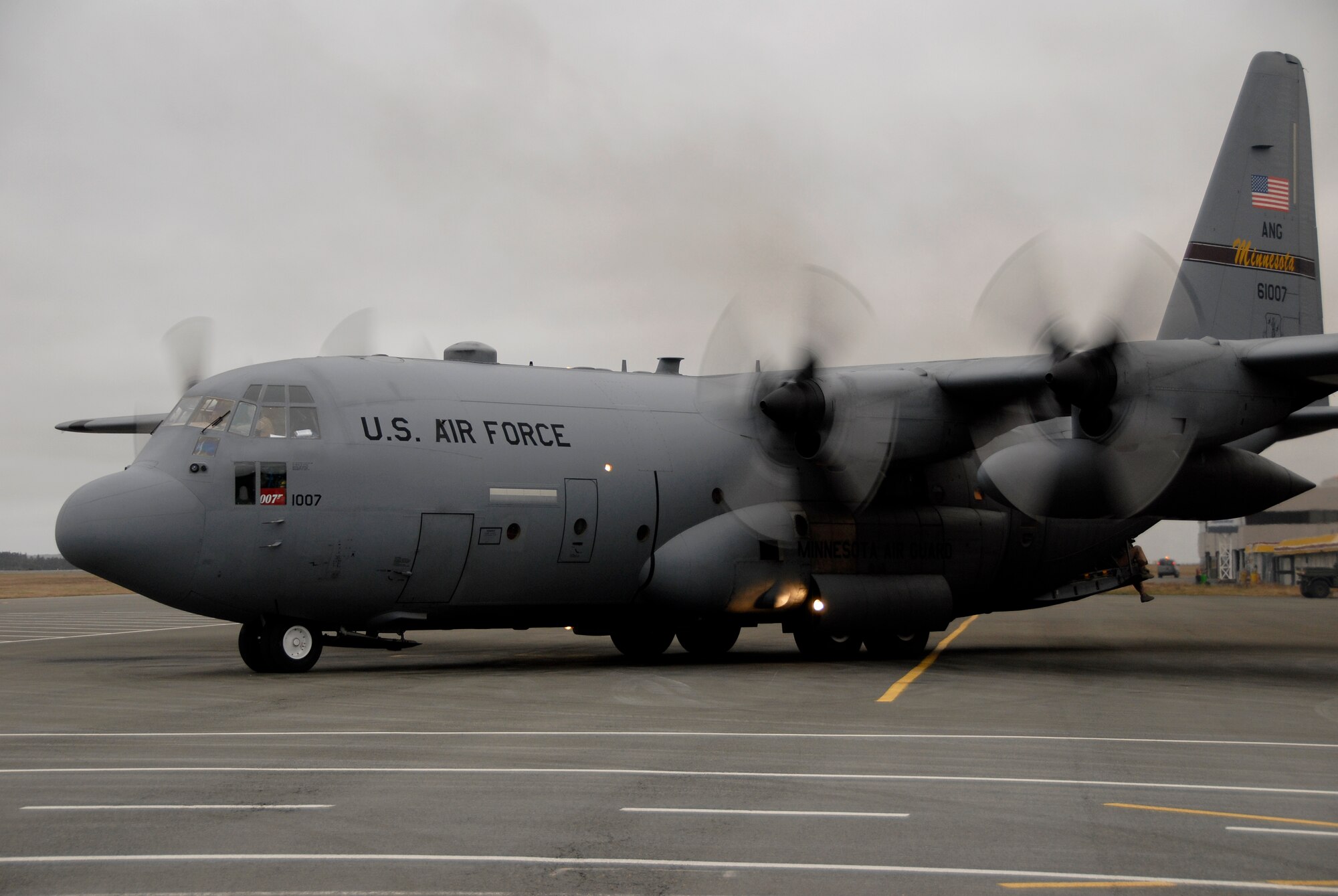 A C-130 H3 "Hercules" from the 133rd Airlift Wing of St. Paul, Minn. lands at a location in Canada, en route from Afghanistan and delivering a part to another C-130 from the Minn. Air National Guard. The second aircraft waits to fly on to Afghanistan.