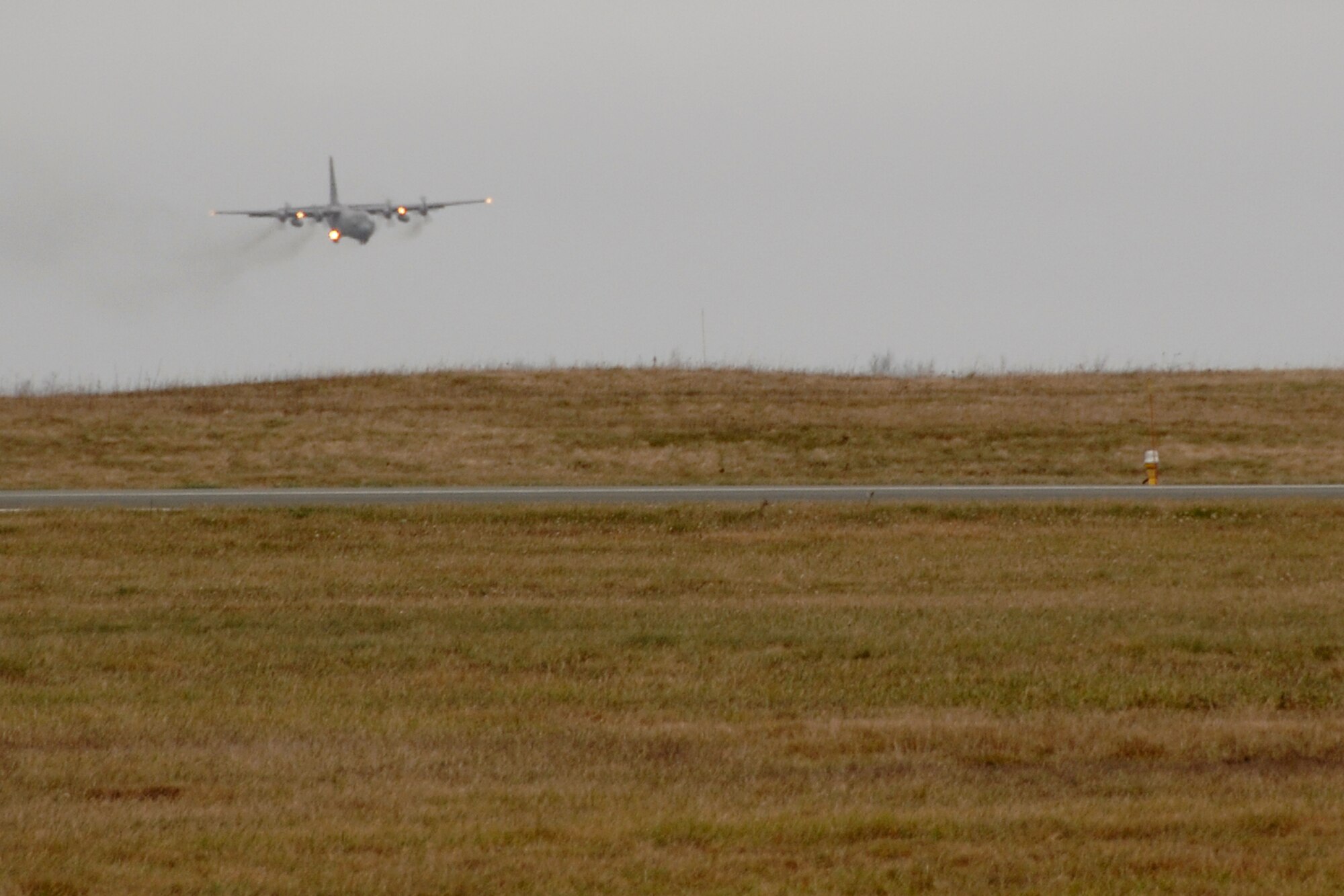 A C-130 H3 "Hercules" from the 133rd Airlift Wing of St. Paul, Minn. lands at a location in Canada, en route from Afghanistan and delivering a part to another C-130 from the Minn. Air National Guard. The second aircraft waits to fly on to Afghanistan.