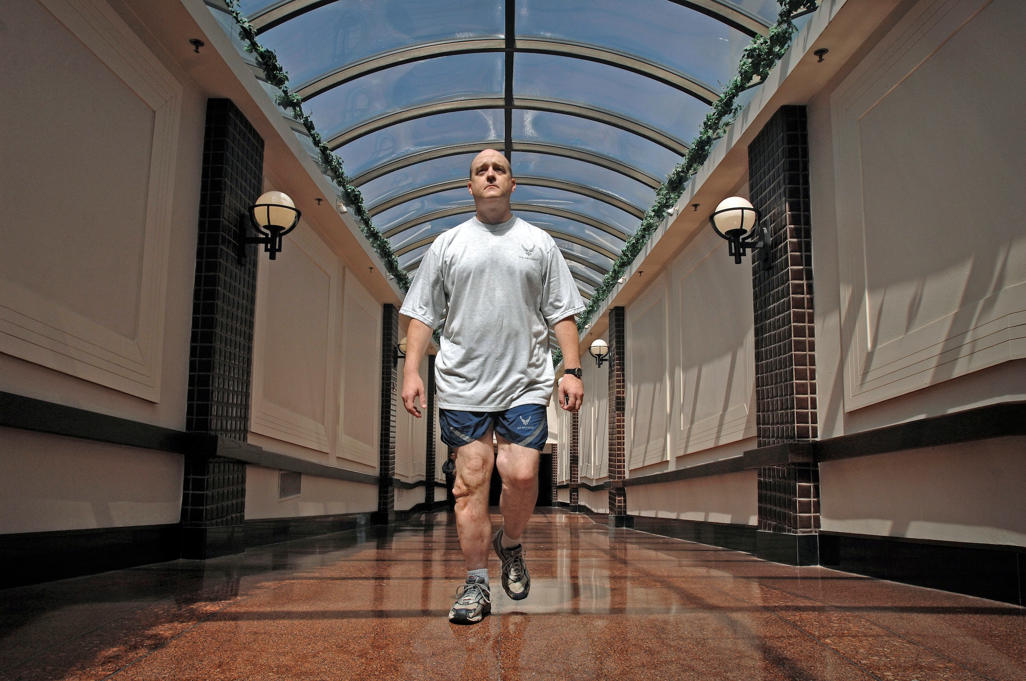 Maj. Matthew Conlan walks a couple of miles regularly through the cavernous tunnel system of shops and restaurants below his office in Crystal City, downtown Arlington, Va. Major Conlan was injured in Afghanistan in 2005 and returned to active duty to work at the Air Force's counter-improvised explosive device office in Arlington. (Defense Department photo/Fred W. Baker III) 
