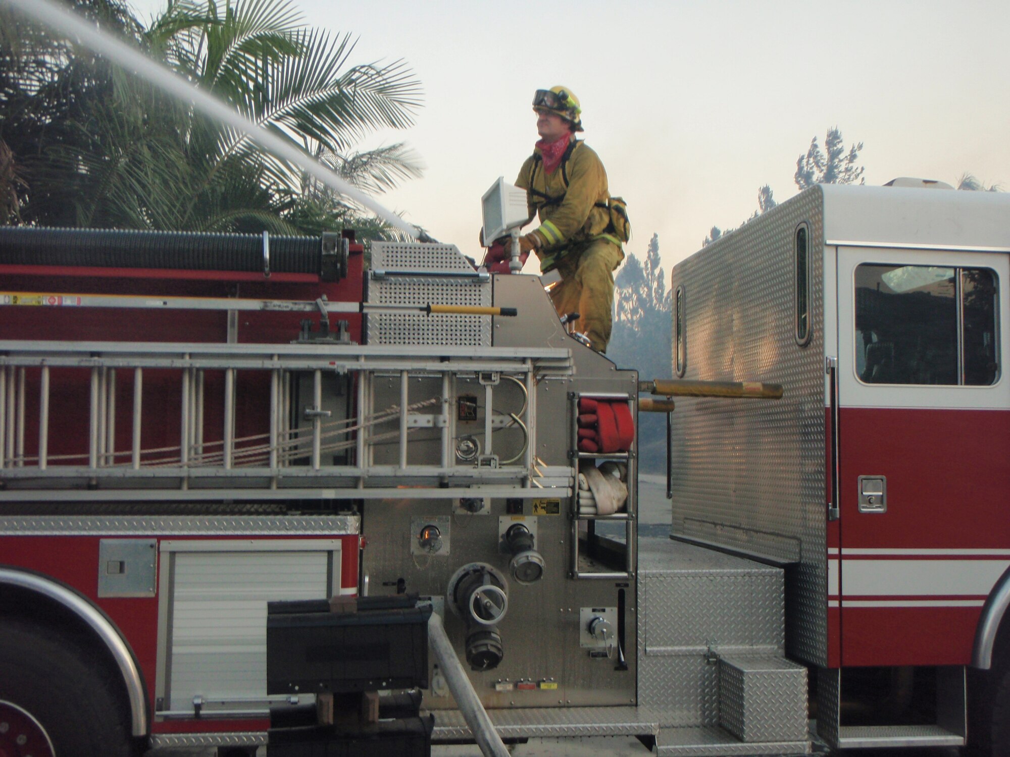 Michael Russell of the March Air Reserve Base (Calif.) Fire Department operates the master stream hose on a base fire truck. After seeing Mr. Russell on a TV news report, one Anaheim Hills, Calif., homeowner credited Mr. Russell's strike team with saving his home from a neighborhood fire. (Courtesy photo)