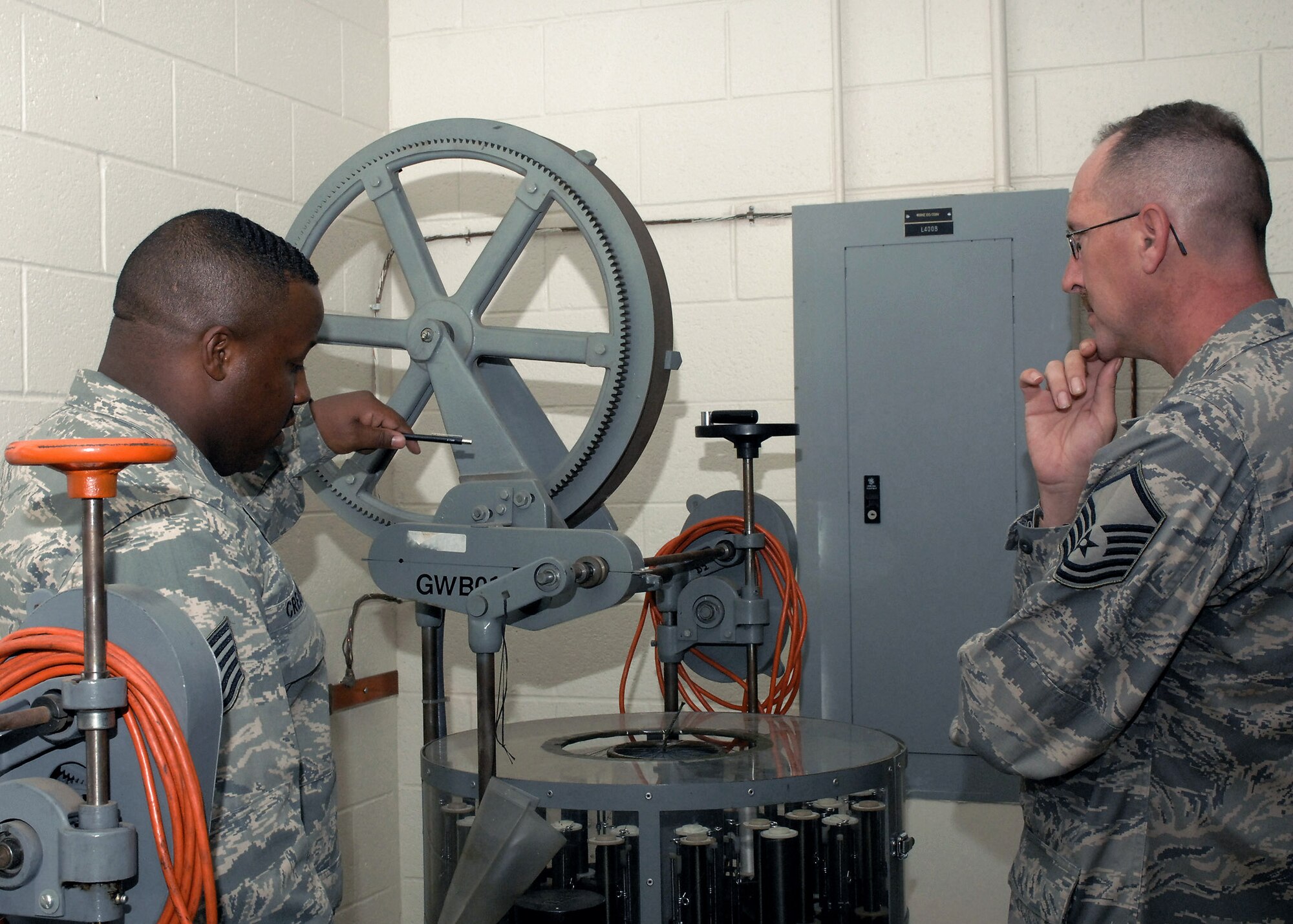 Tech. Sgt. Kent Creamer shows Master Sgt. William Keely  how the wire braiding machine operates. Volunteer Protection Program members and Sergeant Keely toured Cannon Air Force Base, N.M., to look at protection features on equipment being used at the base Nov. 3 to 7. Sergeant Creamer is assigned to the 27th Special Operations Component Maintenance Squadron. Sergeant Keely is assigned to the 27th Special Operations Wing Safety Office, (U.S. Air Force photo/Airman 1st Class James R. Bell)