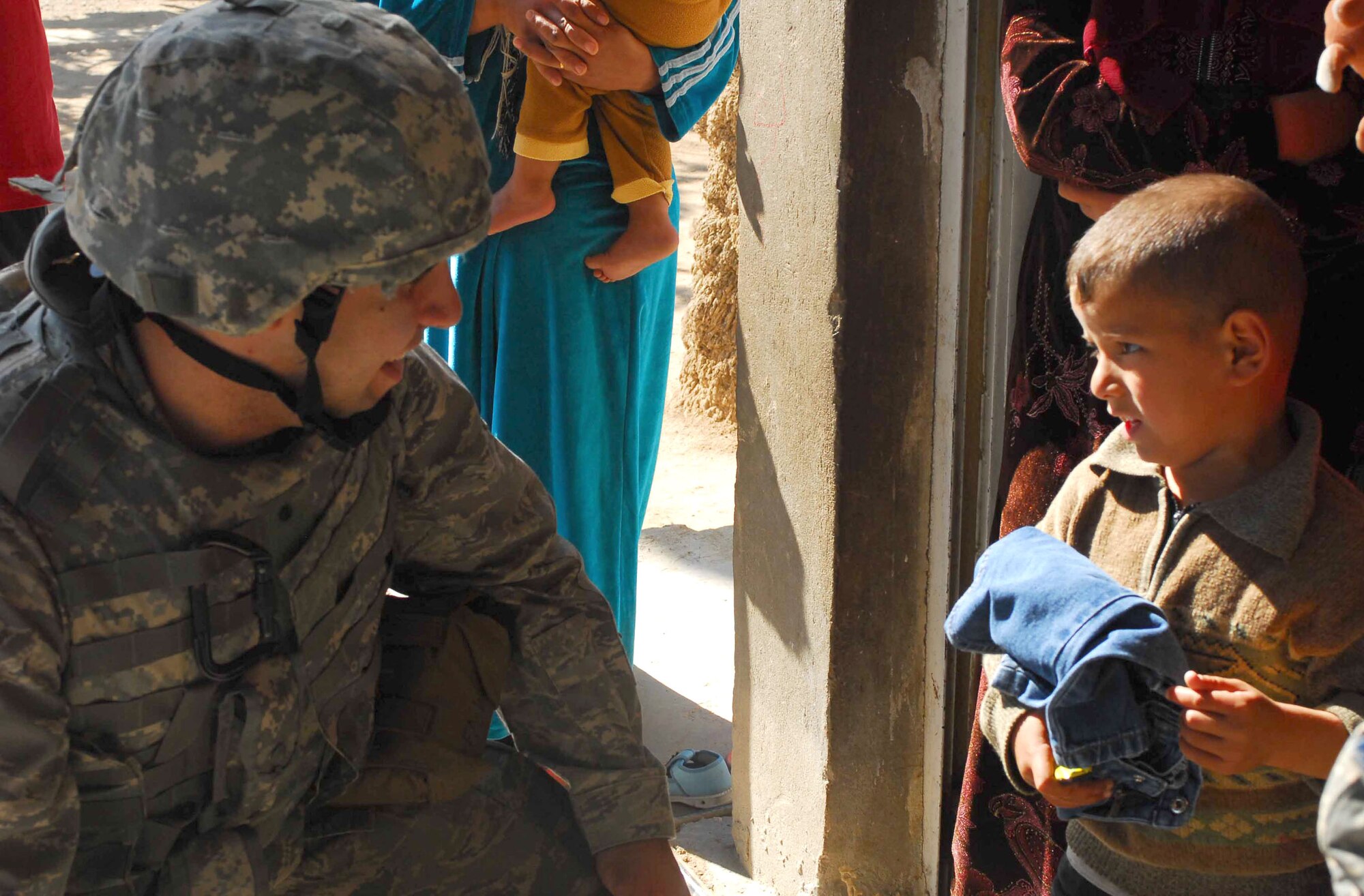 Airman 1st Class David Salanitri, left, Joint Operations Center Public Affairs, Multi-National Corps-Iraq, speaks with a child in Abu Ghraib, Iraq. Airman Salanitri was part of a humanitarian mission that distributed toys and clothing donated by an elementary school back in the states to more than 200 Iraqi children. Airman Salanitri, who’s deployed from the 81st Training Wing Public Affairs Office, described the mission as “one of the best military experiences I’ve had.”  He’s scheduled to return from his first deployment this week.