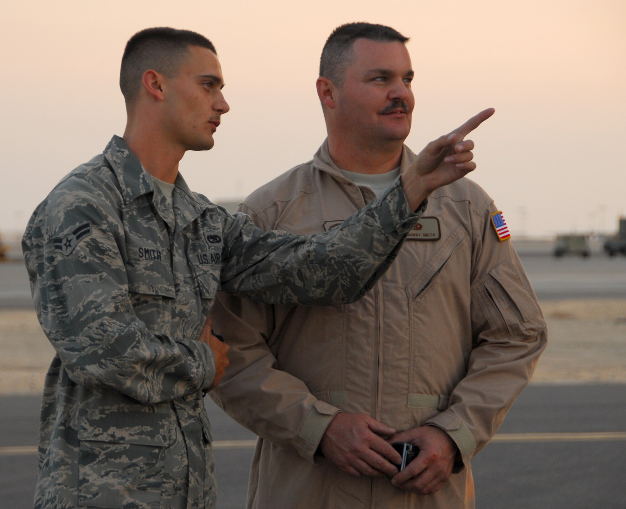 SOUTHWEST ASIA -- Airman 1st Class Aaron Smith talks with his father, Master Sgt. Bobby Smith, before he boards a flight to Andrews Air Force Base, Md. Sergeant Smith, a flying crew chief, had the opportunity to spend time with his son at a base in Southwest Asia while transiting through the Persian Gulf region. Airman Smith is also a crew chief, and is deployed to the 386th Air Expeditionary Wing from Dyess AFB, Texas.
