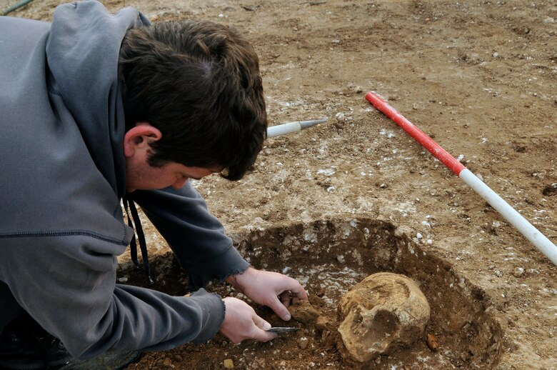 John Sims, an archaeologist with the Suffolk County Council Archaeological Service, removes the collar bone from a skeleton Nov 24 at RAF Lakenheath, England. Out of the five bodies found two have so far been removed to be further studied. (U.S. Air Force photo by Airman 1st Class Perry Aston)