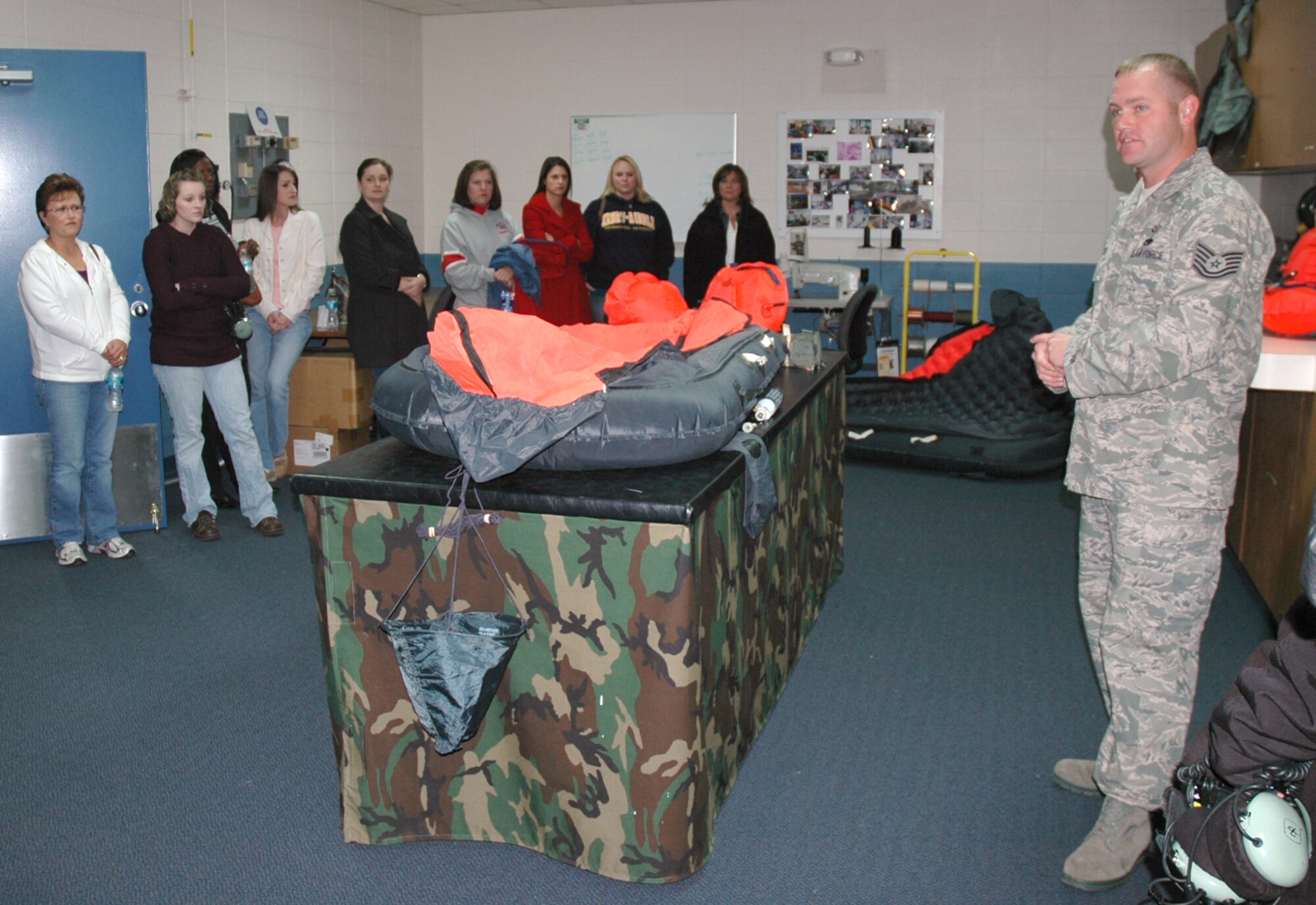 Tech. Sgt. Chris Becker, 919th Operations Support Squadron aircrew flight equipment craftsman, briefs reserve spouses on a tour of the survival shop at Duke Field. Sergeant Becker explained the operational use of survival equipment used in flight operations and showed how some life-saving floatation devices are deployed. (U.S. Air Force Photo/Dan Neely)