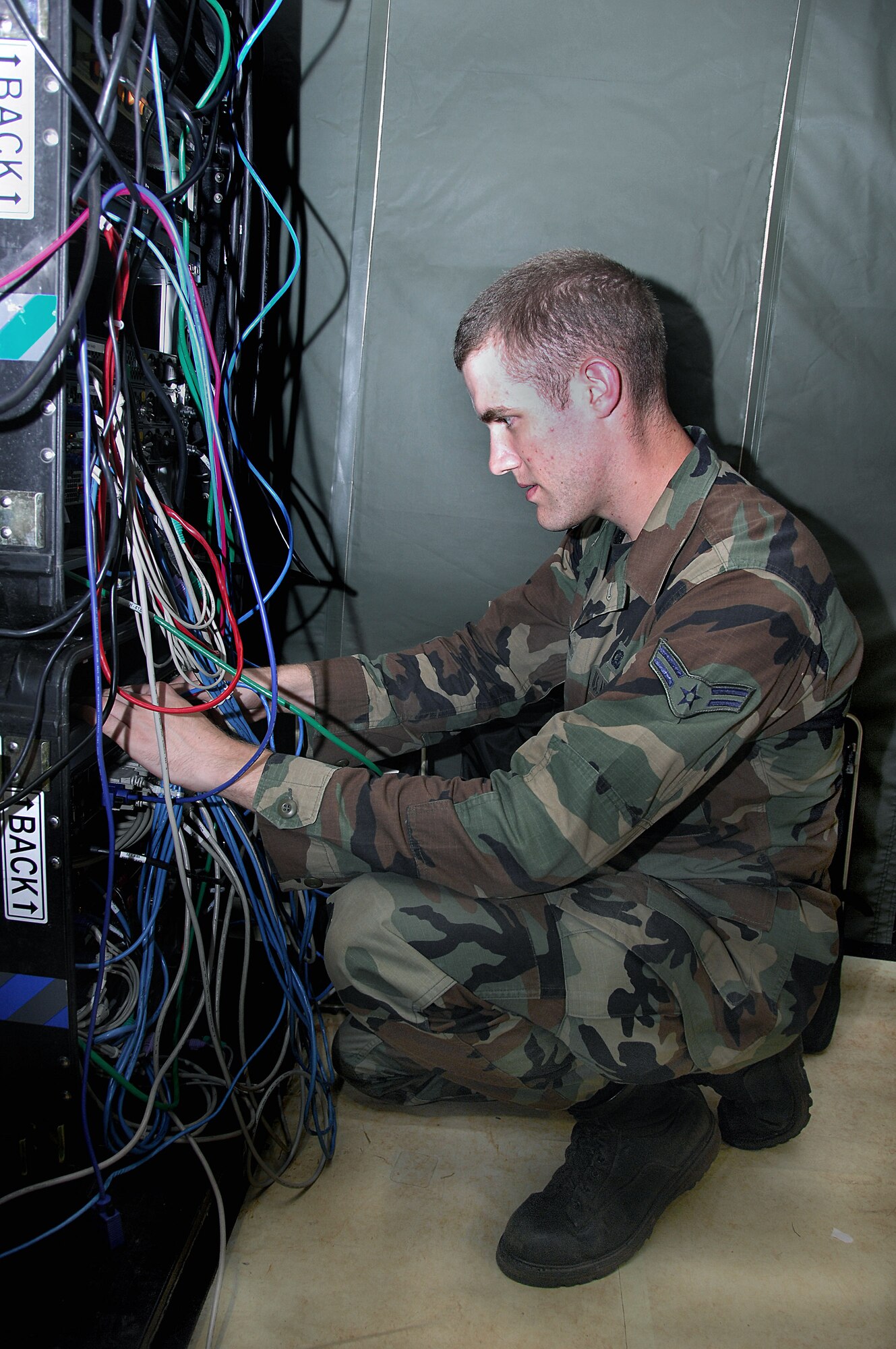 Airman 1st Class Joseph Lapthorne ensures local area connection cables are secure during the squadron's Dragon Thunder field training exercise Nov. 20 at Andersen Air Force Base, Guam. Airman Lapthorne is a 644th Combat Communications Squadron network control center operator. (U.S. Air Force photo/Senior Airman Shane Dunaway) 

