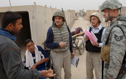 Staff Sgt. Trevor Birch works with local Iraqis and cultural advisors outside an entry control point before running patients to the Air Force Theater Hospital for treatment at Joint Base Balad, Iraq, Nov. 20. U.S. servicemembers contracted a project, which included a new waiting room and security fence upgrade, at the ECP to enhance relations with the Iraqis who visit here to work, conduct business or seek medical assistance. Birch, of the 332nd Expeditionary Medical Group Host Nation Patient Liaison Office, is deployed from Lackland Air Force Base, Texas. He is a native of Midland, Mich. (U.S. Air Force photo/Tech. Sgt. Erik Gudmundson)