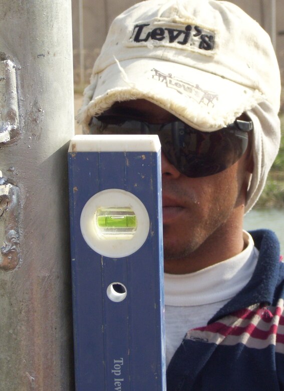 A local Iraqi contactor uses precision tools to work on a new fencing project for an entry control point at Joint Base Balad, Iraq, Sept. 22. Army and Air Force servicemembers worked together to contract the project, which included a new waiting room, that will improve the security of the ECP and enhance relations with the Iraqis who visit here to work, conduct business or seek medical assistance. (U.S. Air Force photo/Maj. William Patience)