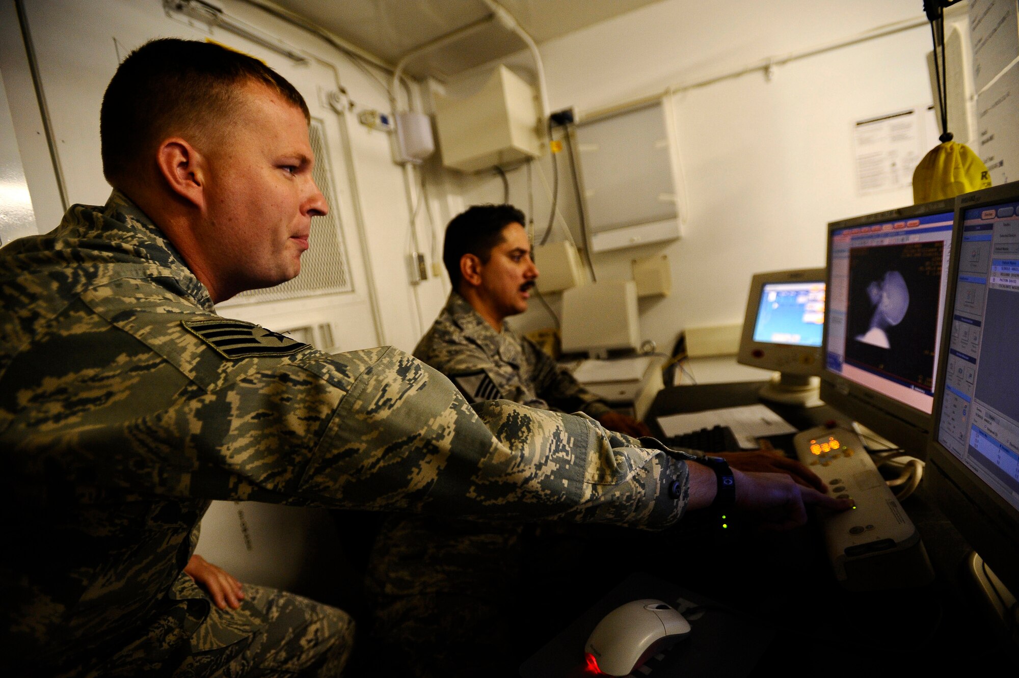 Staff Sgt. Joshua Livingston instructs Master Sgt. Oscar Sotomayor where to put scan planes on a patient during a CT scan Nov. 21 at Joint Base Balad, Iraq. The CT scan will aid doctors in diagnosing medical conditions that the patient may have. Sergeant Livingston is assigned to the 332nd Expeditionary Medical Support Squadron and deployed from Keesler Air Force Base, Miss. His hometown is Rapid City, S.D. Sergeant Sotomayor, the NCO in charge of diagnostic imaging with the 332nd Expeditionary Medical Support Squadron and a native of San Antonio, is deployed from Langley AFB, Va. (U.S. Air Force photo/Airman 1st Class Jason Epley) 
