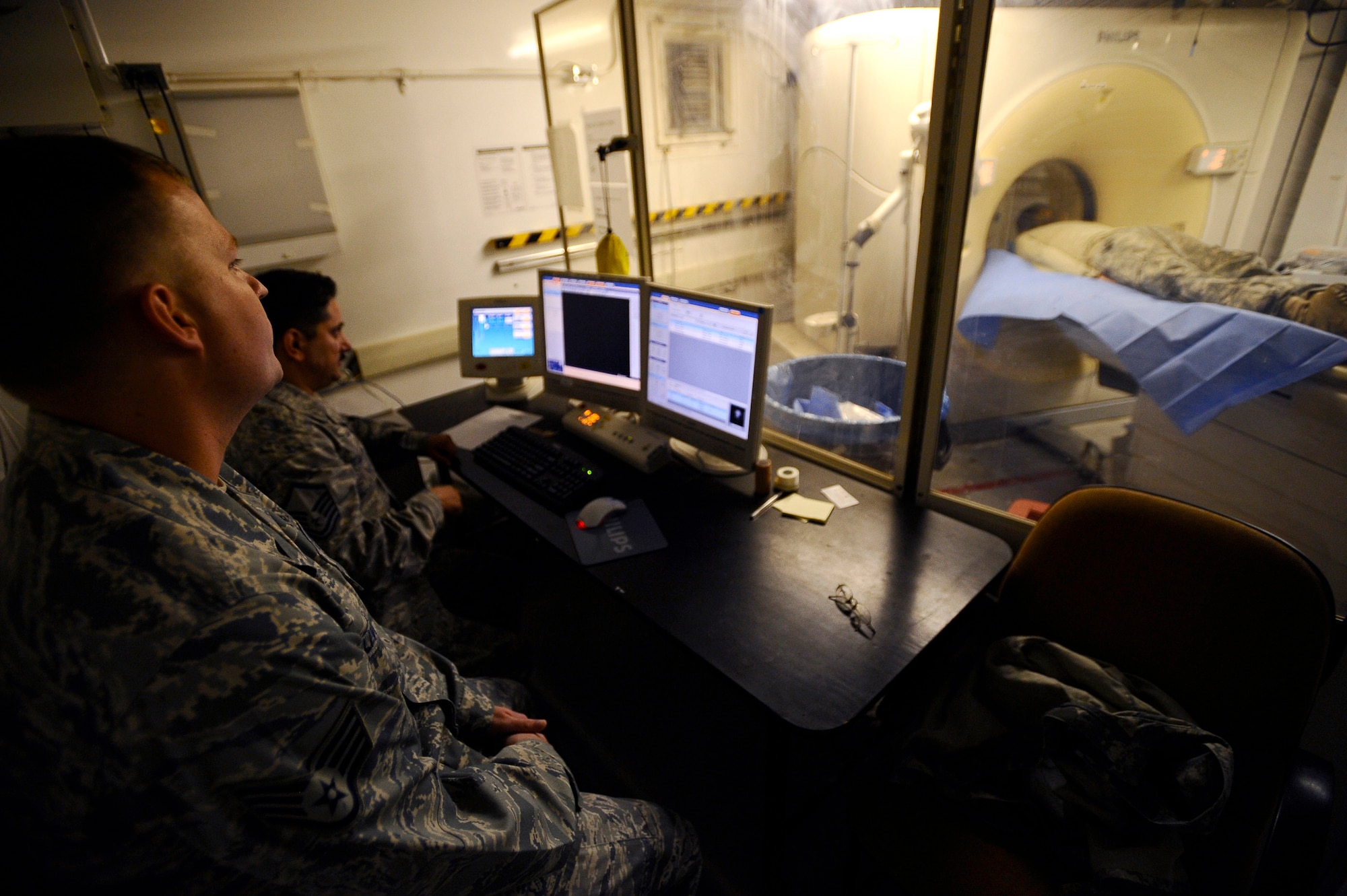 Staff Sgt. Joshua Livingston and Master Sgt. Oscar Sotomayor watch as a patient goes through a CT scan Nov. 21 at Joint Base Balad, Iraq. The CT scan will aid doctors in diagnosing medical conditions that the patient may have. Sergeant Livingston, a CT technologist with the 332nd Expeditionary Medical Support Squadron and native of Rapid City, S.D., is deployed from Keesler Air Force Base, Miss. Sergeant Sotomayor, the NCO in charge of diagnostic imaging with the 332nd Expeditionary Medical Support Squadron and a native of San Antonio, is deployed from Langley AFB, Va. (U.S. Air Force photo/Airman 1st Class Jason Epley) 
