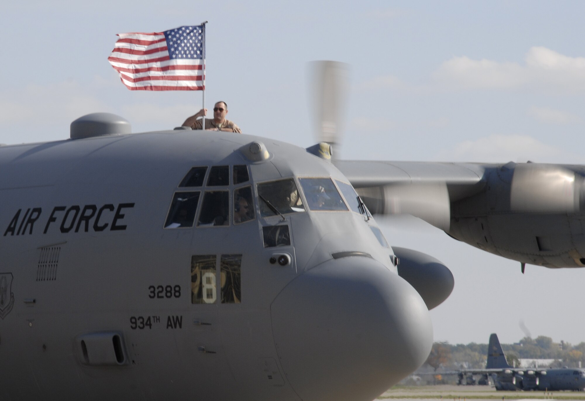 Capt. Andy Thomas, 96th Airlift Squadron, proudly waves the flag from a C-130 cockpit as the aircraft returns from a deployment to Southwest Asia. (Air Force Photo/Staff Sgt. Michael Edmond)