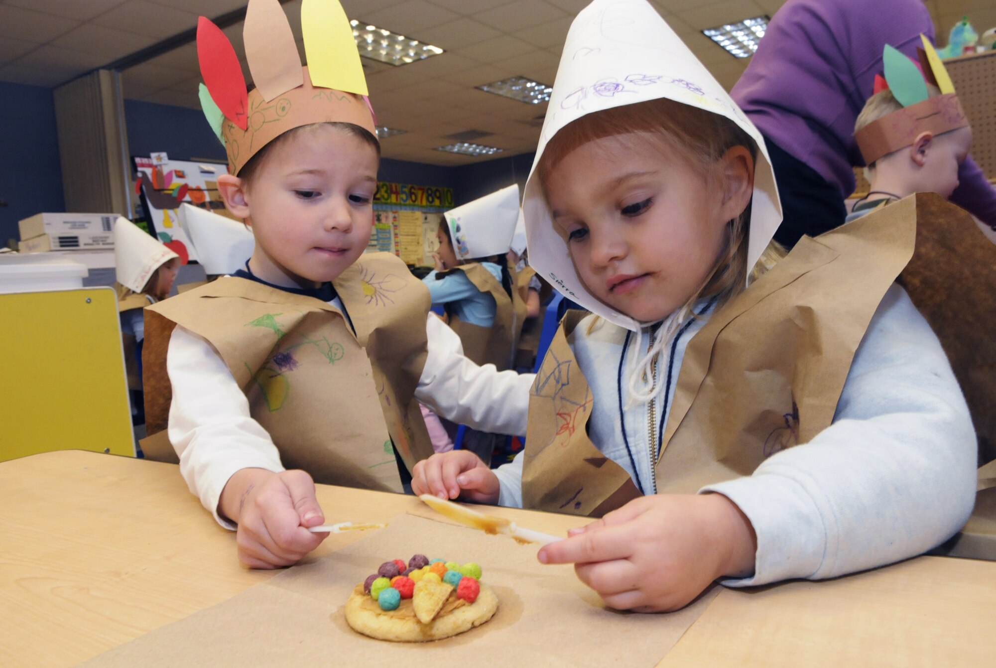 Ryan Underwood and Sierra Sheward work together on a cornucopia cookie in Beverly Crawford's pre-kindergarten class at Robins Elementary Nov. 19. The Class dressed as pilgrims and Native Americans to learn about Thanksgiving. U. S. Air Force photo by Sue Sapp