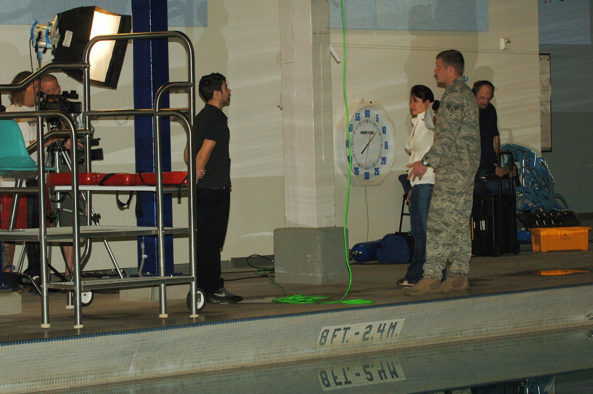 Senior Airman Ethan Jago listens to instructions from the MTV crew before filming begins Nov. 18 at the aquatic center at Fairchild Air Force Base, Wash.  The MTV crew was at Fairchild to film several episodes for the "How To Show" seen on MTV.com and MTV mobile.  Airman Jago, a survival, evasion, resistance and escape specialist with the 66th Training Squadron, was chosen to narrate for the episode demonstrating the steps involved in escaping from a submerged vehicle.  (U.S. Air Force photo/Senior Airman Jocelyn A. Ford)