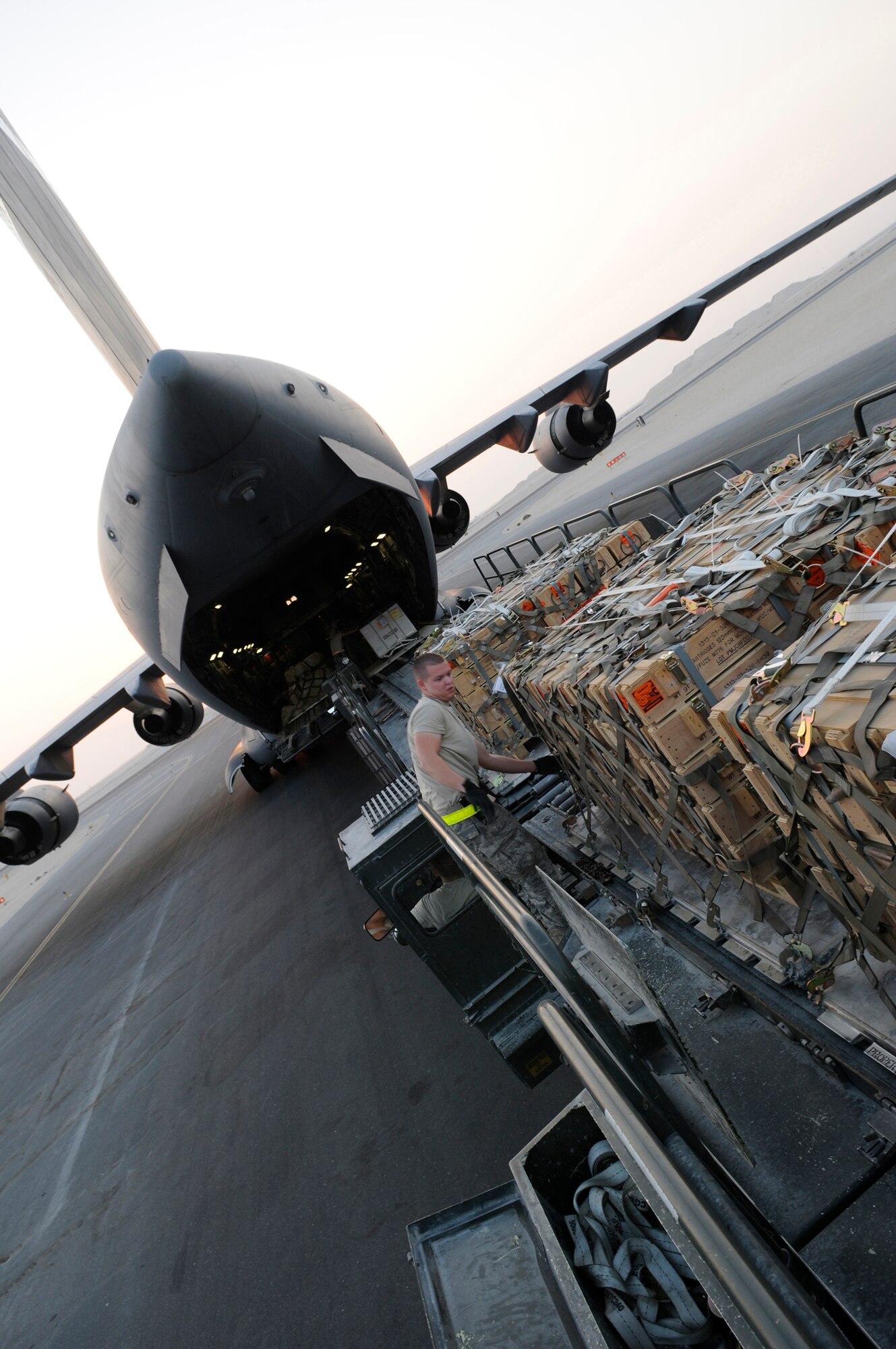 Airman 1st Class Brian Foxworth, an air transportation journeyman assigned to the 8th Expeditionary Air Mobility Squadron, checks the cargo netting  on a pallet after it was moved from a C-17 Globemaster III onto a 60K loader, Nov. 25, 2008, at an undisclosed air base in Southwest Asia.  Chains are used to keep the pallet loads from shifting during transit to the storage area.  Airman Foxworth is a native of Austin, Texas, and is deployed from McGuire Air Force Base, N.J. He is here supporting Operations Iraqi and Enduring Freedom and Joint task Force-Horn of Africa.  (U.S. Air Force photo by Tech. Sgt. Michael Boquette/Released)