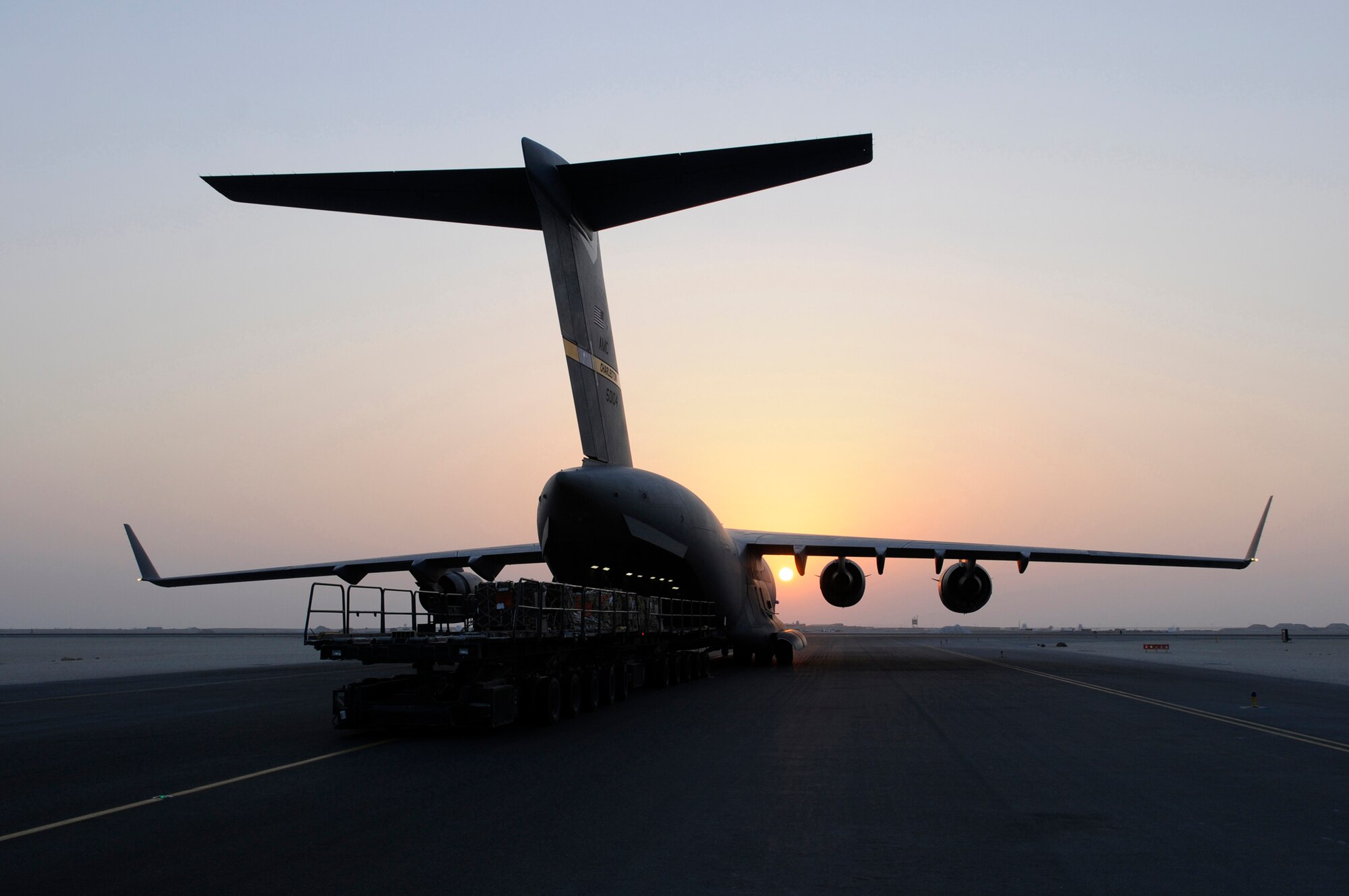 Multiple 60K loaders are used to offload cargo from a C-17 Globemaster III as the sun sets Nov. 25, 2008, at an undisclosed air base in Southwest Asia.  The C-17 is capable of rapid strategic delivery of troops and all types of cargo to main or forward operating bases in the Central Command area of responsibility. The C-17 is here in support of Operations Iraqi and Enduring Freedom and Joint Task Force-Horn of Africa.  (U.S. Air Force photo by Tech. Sgt. Michael Boquette/Released)