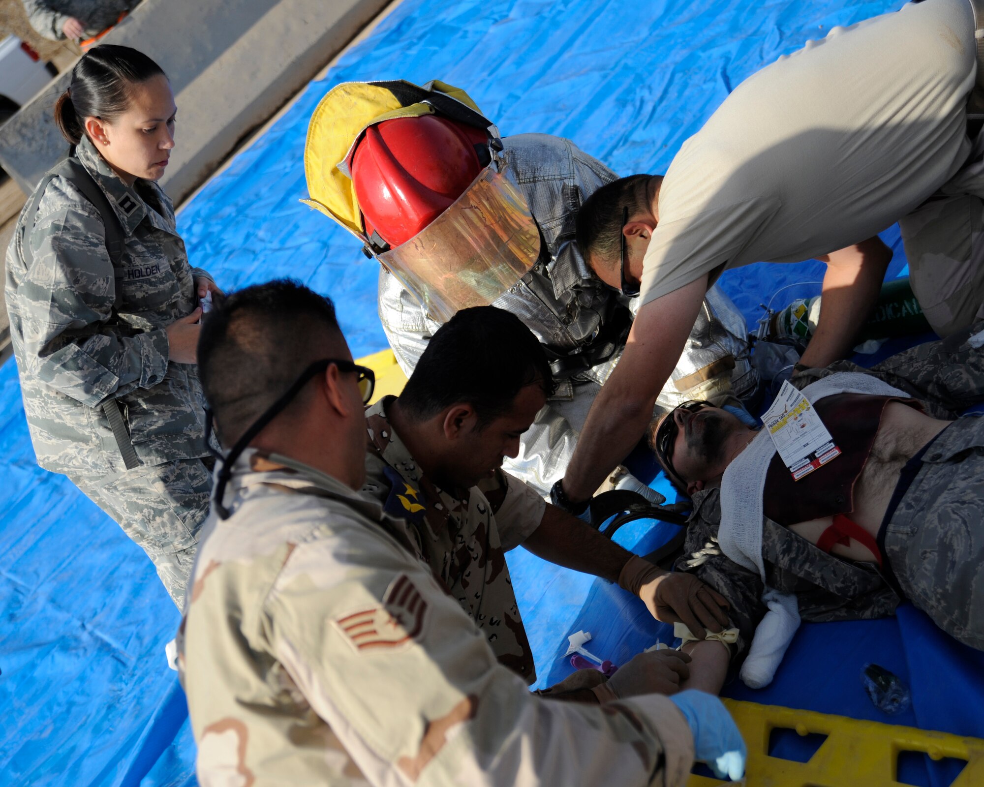 Capt. Sunny Holden, left, chief medical advisor for the 321st Air Expeditionary Advisory Squadron, watches over U.S. and Iraqi emergency response personnel as they provide medical care to a mock casualty of a C-130 accident during a major accident response exercise at New Al-Muthana Air Base, Iraq on Nov. 21, 2008. Holden is deployed from the 1st Medical Operations Squadron, Langley Air Force Base, Va. (U.S. Air Force photo/Staff Sgt. Paul Villanueva II)