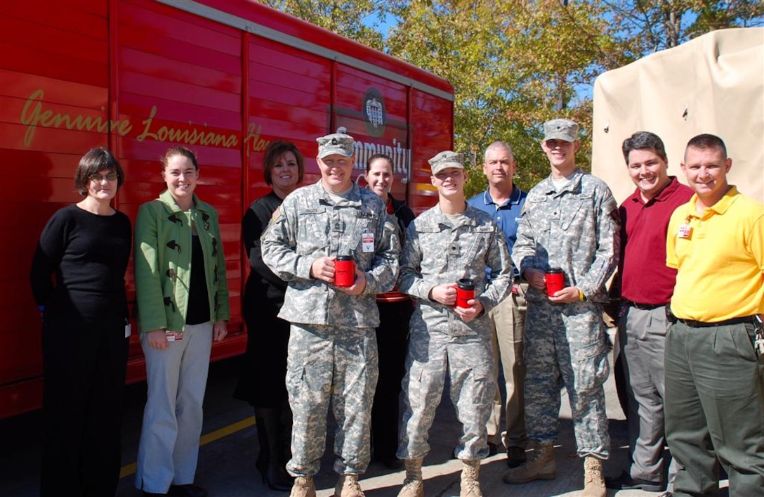 Community Coffee employees pose with soldiers from the Louisiana National Guard’s Headquarters and Headquarters Company, 225th Engineer Brigade of Pineville, La. The soldiers will depart in December on a year-long deployment, but not without their Community Coffee, thanks to a donation of nearly 28,000 cups of coffee by the Louisiana business. U.S. Army photo by Sgt. Rebekah L. Malone