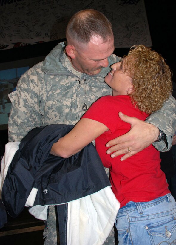 Indiana Army National Guard Sgt. 1st Class Byron Moore embraces his wife Nicola during a ceremony on Stout Field in Indianapolis, Nov. 20, 2008. Moore, a platoon sergeant with Troop B, 1st Battalion, 152nd Reconnaissance, Surveillance, and Target Acquisition Squadron, deployed with the 76th Infantry Brigade Combat Team in March. 