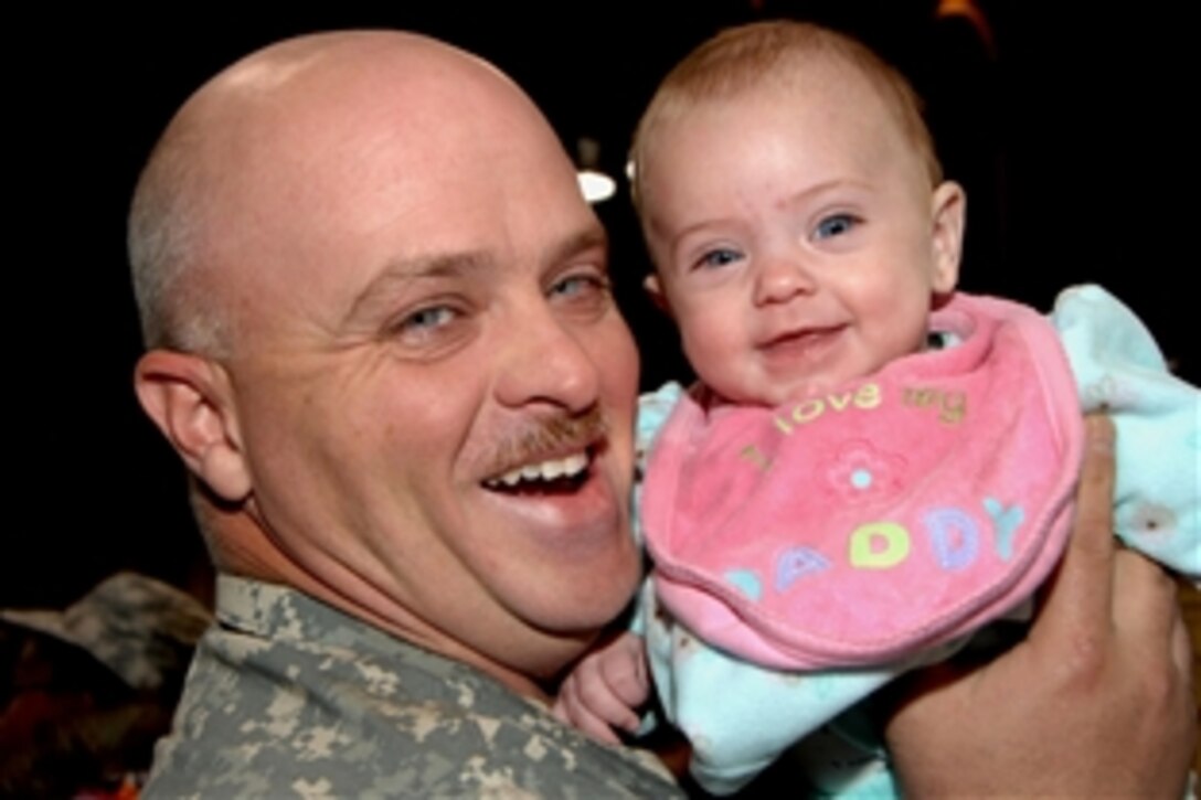 Indiana National Guard Spc. Charles Deas smiles with his 4-month-old daughter Andrea at a ceremony on Stout Field in Indianapolis,Ind., Nov. 25, 2008, after more than nine months supporting Operation Iraqi Freedom. Deas is assigned to Company A, 113th Support Battalion.