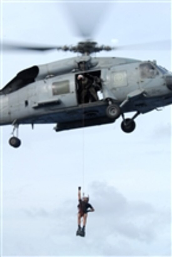 A rescue swimmer is lowered from an HH-60H Knight Hawk helicopter assigned to Helicopter Anti-Submarine Squadron 4 during a search and rescue demonstration on the aircraft carrier USS Ronald Reagan (CVN 76) while underway in the Pacific Ocean on Nov. 21, 2008.  The demonstration was part of Tiger Cruise, an event that gives friends and family of the ship's sailors the opportunity to spend a week on an aircraft carrier.  