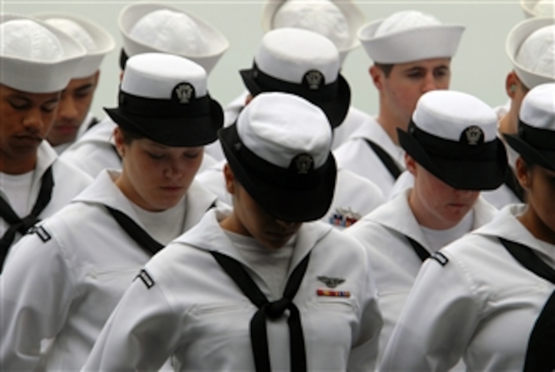 U.S. Navy sailors bow their heads for the benediction during a burial at sea ceremony aboard the aircraft carrier USS Ronald Reagan (CVN 76) while underway in the Pacific Ocean on Nov. 22, 2008.  