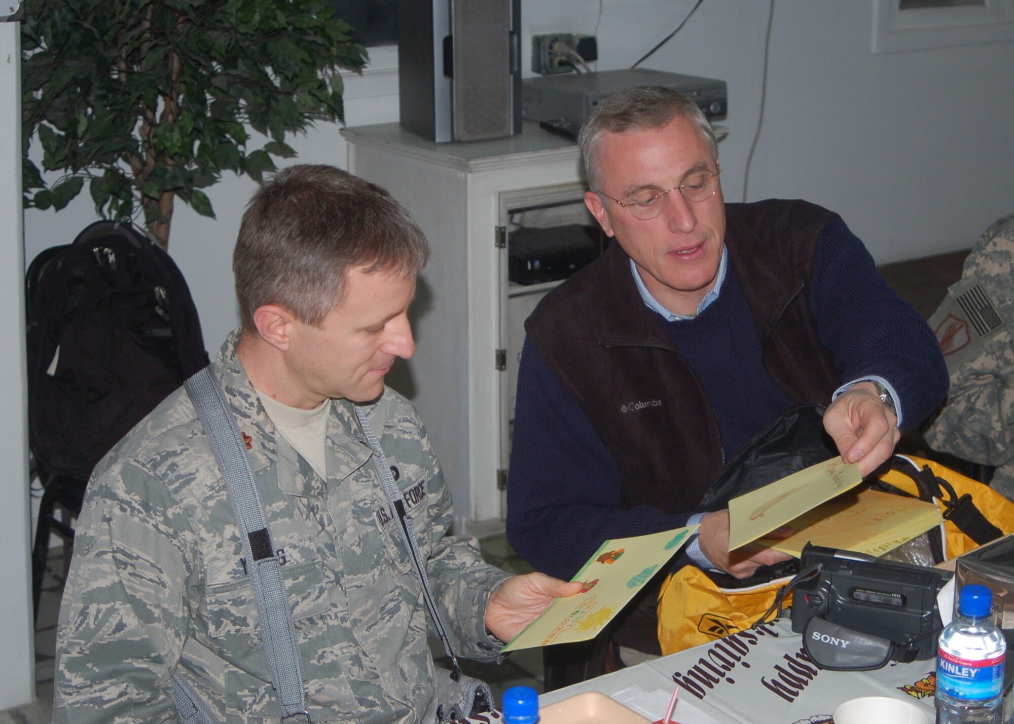 Rep. Tim Murphy, R-Pa., hands out letters from elementary students from Pennsylvania schools to Air Force Maj. Christopher Young during his visit to Camp Eggers on Thanksgiving Day. Murphy was one of six U.S. congressmen to visit Combined Security Transition Command-Afghanistan to talk to servicemembers from their respective states.
