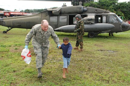 LAS TABLAS, PANAMA-- Master Sgt. James Eidson, a Joint Task Force-Bravo emergency medical technician, escorts a 6-year-old flood victim suffering from respiratory problems, from a UH-60 Black Hawk helicopter Wednesday. The helicopter transported six patients from Las Tablas to here where an ambulance was able to take them to a local hospital. The disaster response task force is here in response to a request from the Panamanian government for assistance with recent flooding caused by prolonged heavy rains in the country. (U.S. Air Force photo by 1st Lt. Candace Park)


