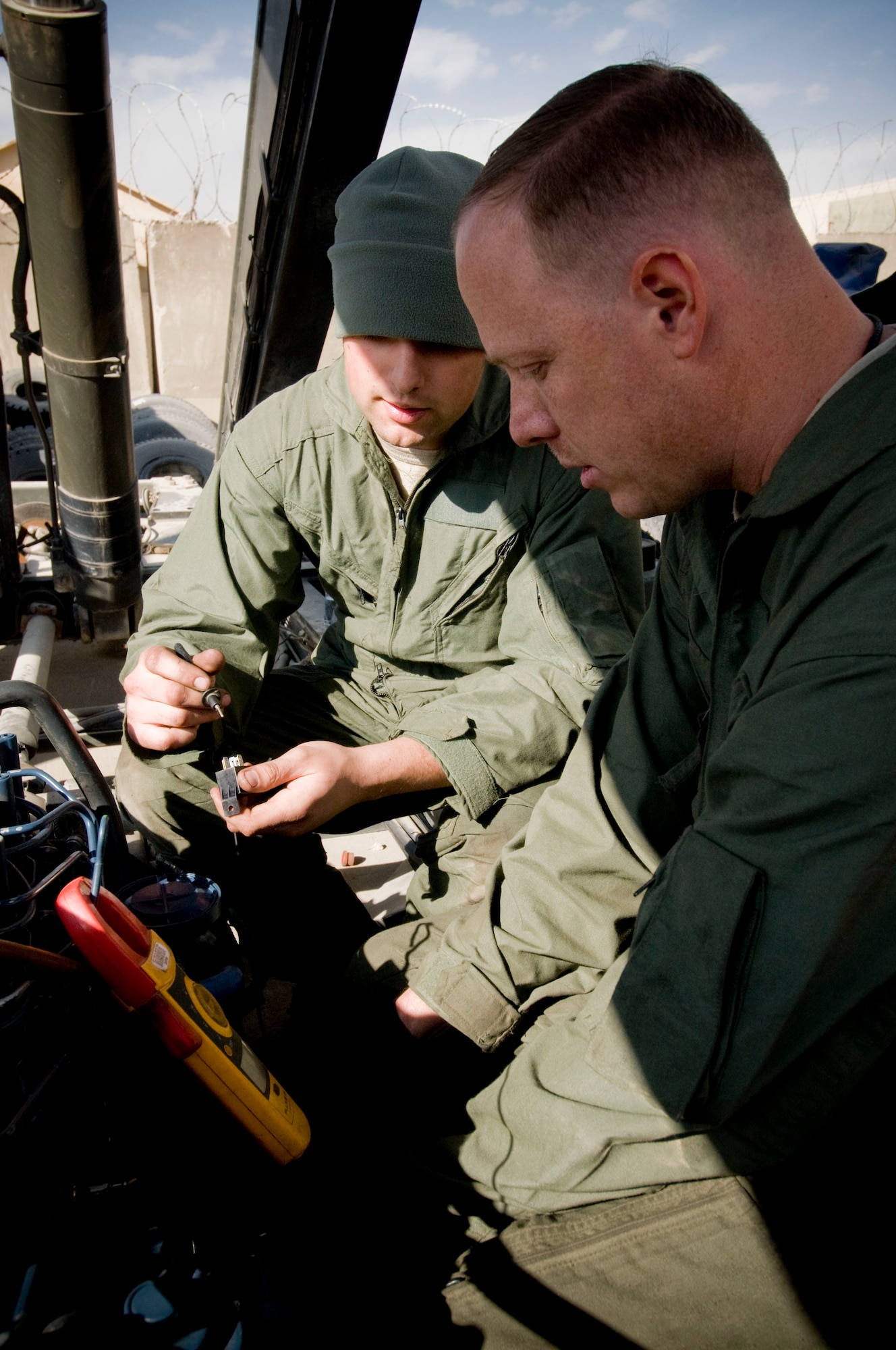 Senior Airman Dustin Porter and Tech. Sgt. Edward Swartz, material handling equipment mechanics, check electrical connections on a k-loader on Thanksgiving, Nov. 27, at Bagram Air Field, Afghanistan. Airman Porter is from Danbury, Conn., and Sergeant Swartz is from Georgetown, Ohio. Both are thankful for the love and support they get from their families. (U.S. Air Force photo by Staff Sgt. Samuel Morse)(Released)