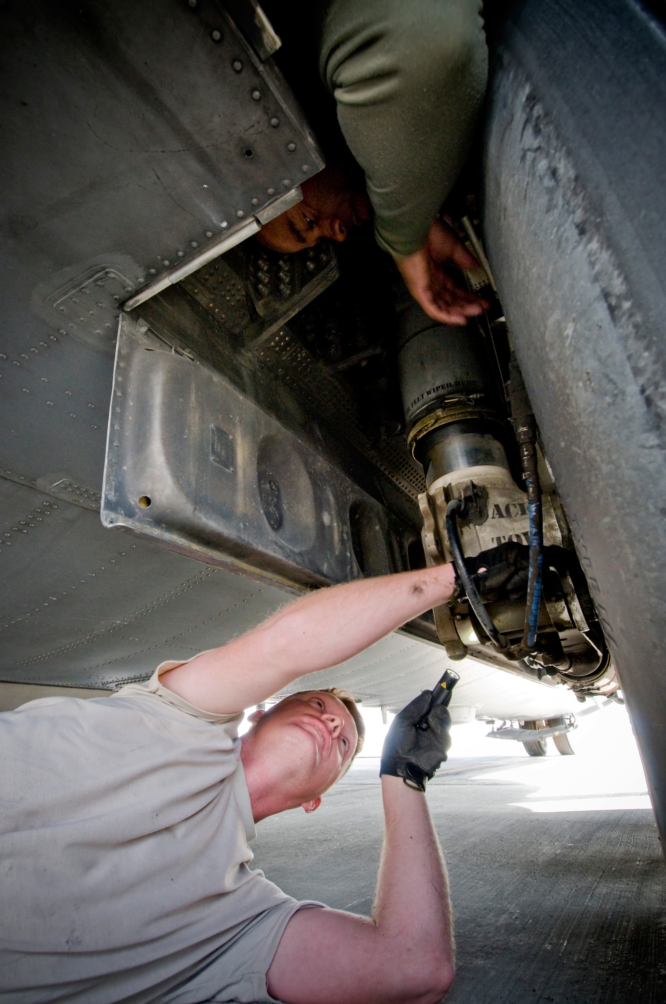 Staff Sgt. Brian Cherry (bottom) and Tech. Sgt. Anthony Freeman, C-130H Aircraft Maintenance Unit crewchiefs, inspect hydraulic lines in the landing gear of a C-130H Hercules on Thanksgiving, Nov. 27, at Bagram Air Field, Afghanistan. Sergeant Cherry and Sergeant Freeman, from Cherryville and Charlotte, N.C. respectively, are thankful for their families, especially Sergeant Cherry, calling his children "the light of my life." (U.S. Air Force photo by Staff Sgt. Samuel Morse)(Released)