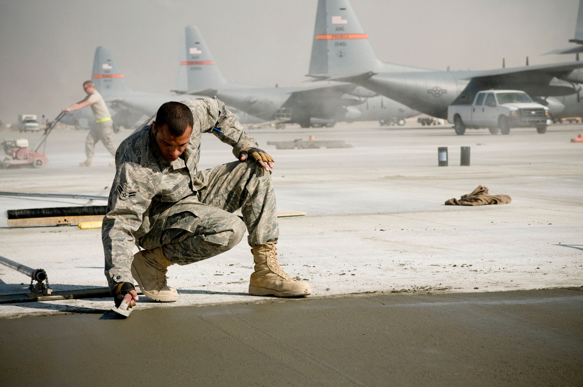 Airman 1st Class Joshua Toth, 455th Expeditionary Civil Engineer Squadron heavy equipment operator, smoothes wet concrete on Thanksgiving, Nov. 27, at Bagram Air Field, Afghanistan. Airman Toth is from Clayton, N.J. and is thankful for being in Afghanistan, serving his country. (U.S. Air Force photo by Staff Sgt. Samuel Morse)(Released)