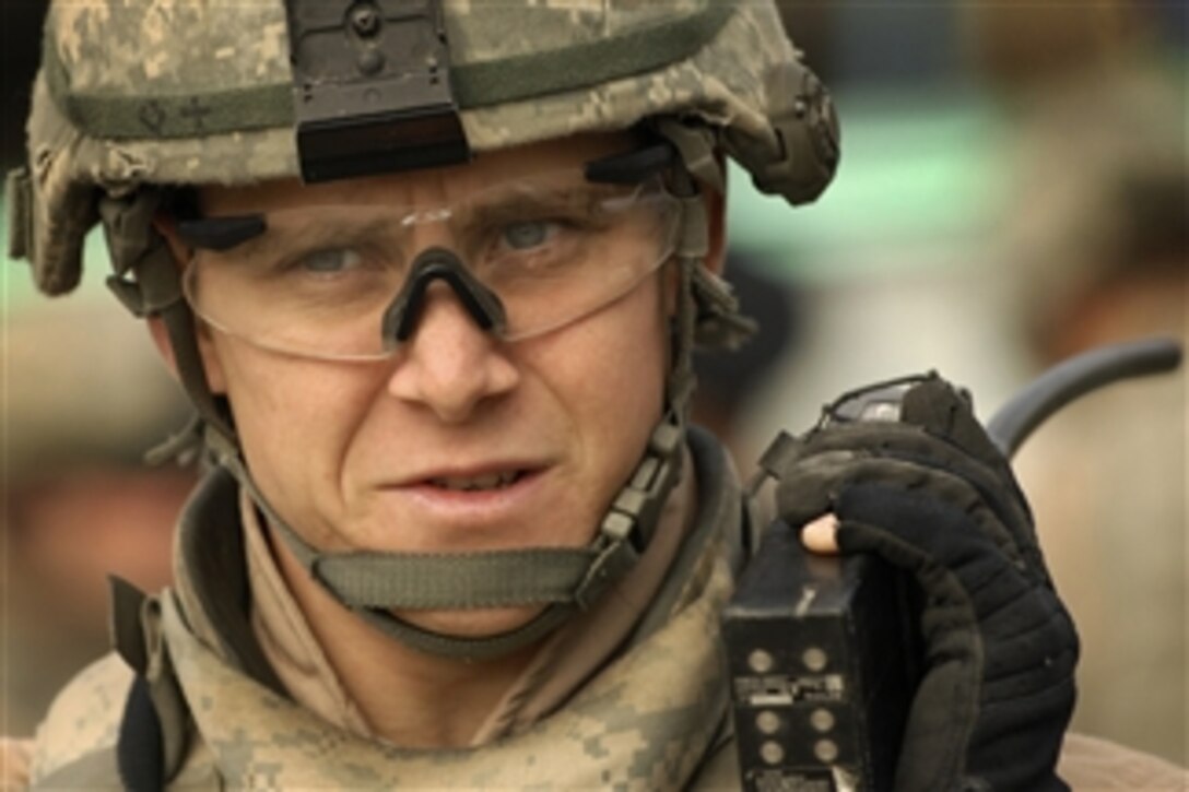 U.S. Air Force Staff Sgt. Peter Casola, assigned to the Detachment 3, 732nd Expeditionary Security Forces Squadron, coordinates troop movement during a joint patrol with Iraqi police and Sons of Iraq members for improvised explosive devices in the Doura district of Baghdad, Iraq, on Nov. 22, 2008.  