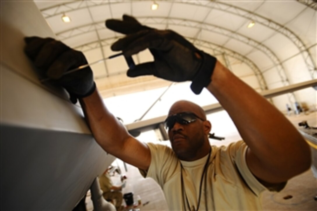 U.S. Air Force Tech. Sgt. Fred Spears secures the satellite communication radom to an MQ-9 Reaper unmanned aerial vehicle at Joint Base Balad, Iraq, on Nov. 22, 2008.  A coalition force of experts from the U.S. Air Force and Royal Air Force deployed to man a new Reaper aircraft maintenance unit.  The unit is attached to the 46th Expeditionary Reconnaissance and Attack Squadron and assumed maintenance duties from General Atomics, which produces the Reaper for these services.  Spears is a Reaper avionics specialist assigned to the 332nd Expeditionary Aircraft Maintenance Squadron.  