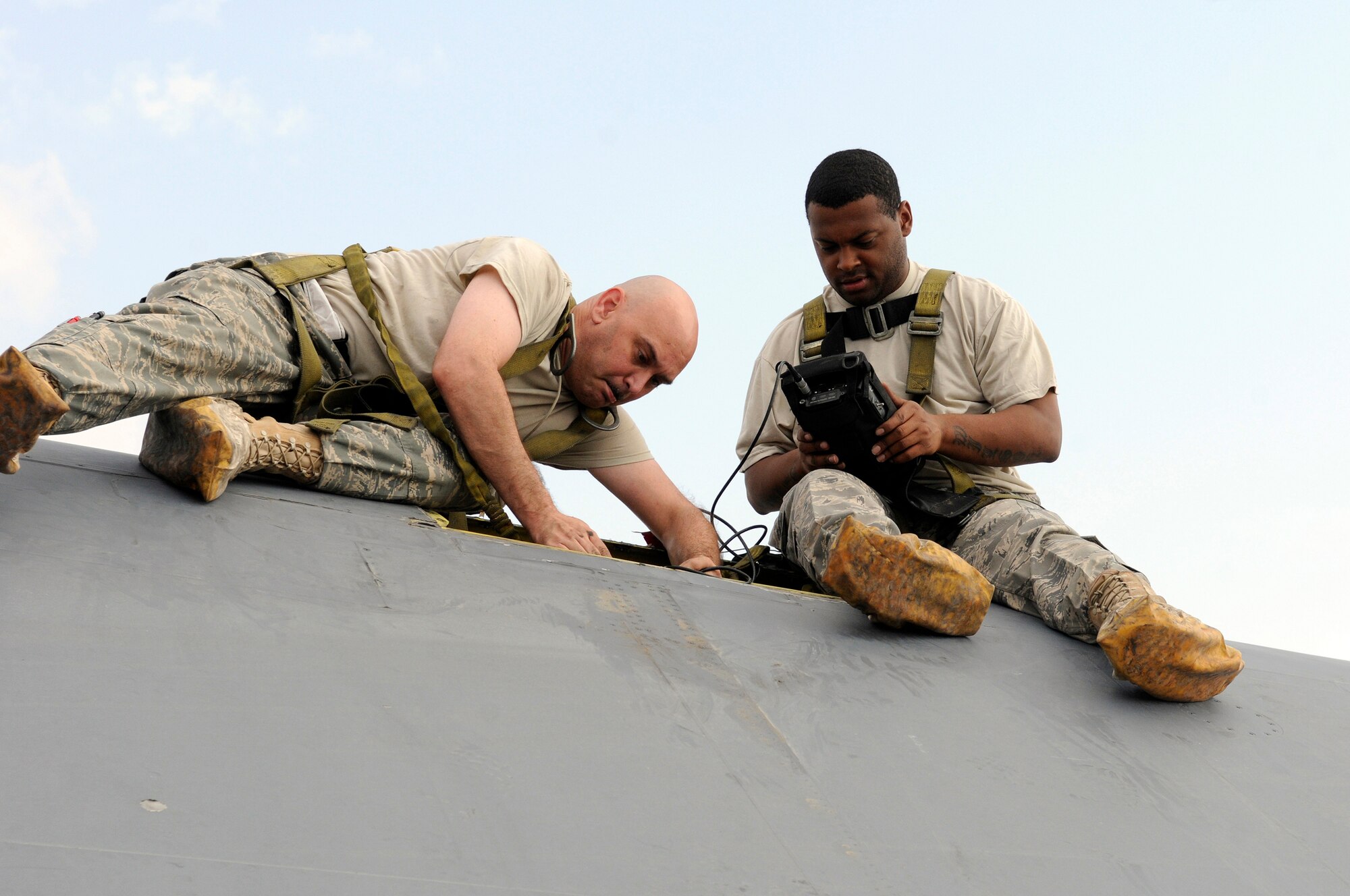 Master Sgt. Samuel O'Donnell, non-destructive inspection craftsman assigned to the 379th Expeditionary Maintenance Squadron, makes connection with a probe to a upper centerline longeron of a B-1B Lancer, while Senior Airman Tysean Wilson, NDI journeyman assigned to the 379 EMXS, uses eddy current to check the structural integrity, Nov. 29, at an undisclosed air base in Southwest Asia.  The non-destructive inspection is used to check for fatigue cracks in this high stress area.  The B-1 is the backbone of America's long-range bomber force. It can rapidly deliver massive quantities of precision and non-precision weapons against any adversary, anywhere in the Central Command area of responsibility.  Sergeant O'Donnell is a native of Omaha, Neb., and deployed from Grand Forks Air Force Base, N.D.  Airman Wilson hails from Yuba City, Calif., and is deployed from Langley AFB, Va.  Both are deployed in support of Operations Iraqi and Enduring Freedom and Joint Task Force-Horn of Africa.  (U.S. Air Force photo by Tech. Sgt. Michael Boquette/Released)