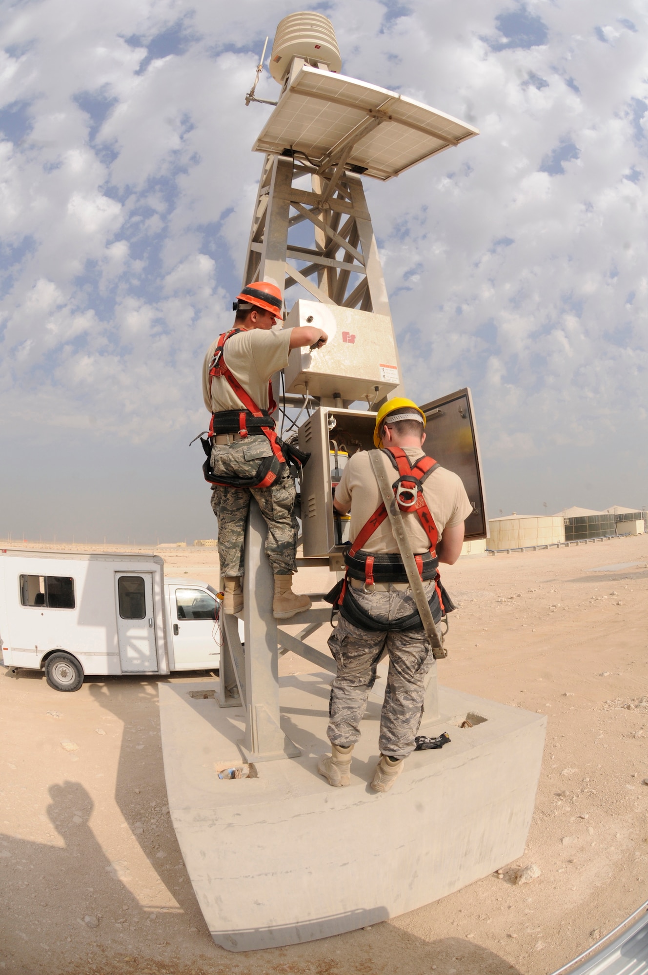 Senior Airman Paul Hunter opens a compartment of the giant voice system while Airman 1st Class Jeffrey Hyatt checks the voltage Nov. 29, at an undisclosed air base in Southwest Asia.  Both are radio maintenance technicians assigned to the 379th Expeditionary Communications Squadron, deployed in support of Operations Iraqi and Enduring Freedom and Joint Task Force-Horn of Africa.  Airman Hunter, a native of Meridian, Miss., is deployed from Key Field Air National Guard, Miss., and Airman Hyatt, a native of Woodbine, Ga., is deployed from Shaw AFB, S.C.  (U.S. Air Force photo by Staff Sgt. Darnell T. Cannady/Released)