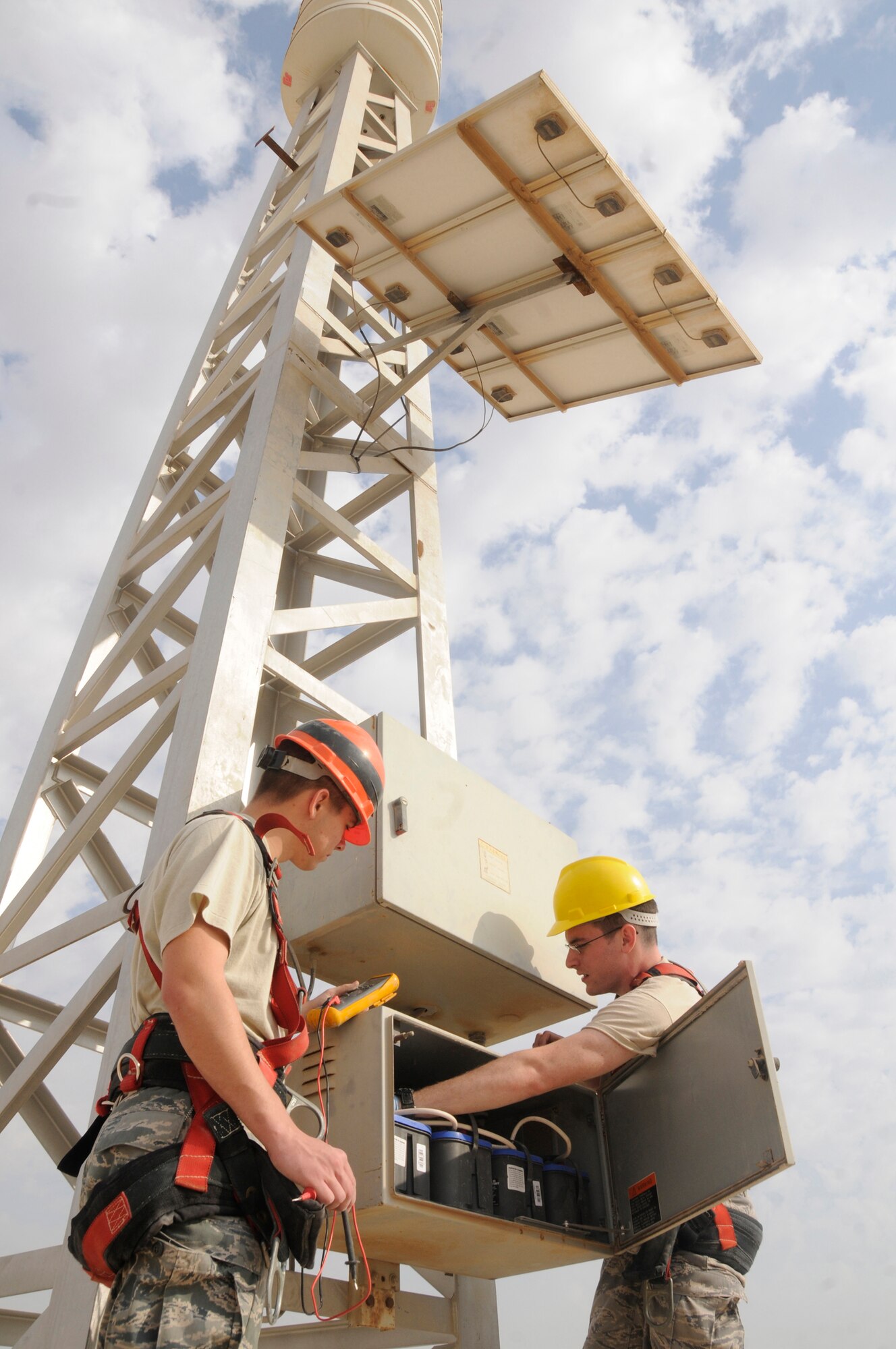 Senior Airman Paul Hunter and Airman 1st Class Jeffrey Hyatt, both radio maintenance technicians assigned to the 379th Expeditionary Communications Squadron, check the voltage of the giant voice system Nov. 29, at an undisclosed air base in Southwest Asia. Airman Hunter, a native of Meridian, Miss., is deployed from Key Field Air National Guard, Miss., and Airman Hyatt, a native of Woodbine, Ga., is deployed from Shaw AFB, S.C. Both are deployed in support of Operations Iraqi and Enduring Freedom and Joint Task Force-Horn of Africa. (U.S. Air Force photo by Staff Sgt. Darnell T. Cannady/Released)