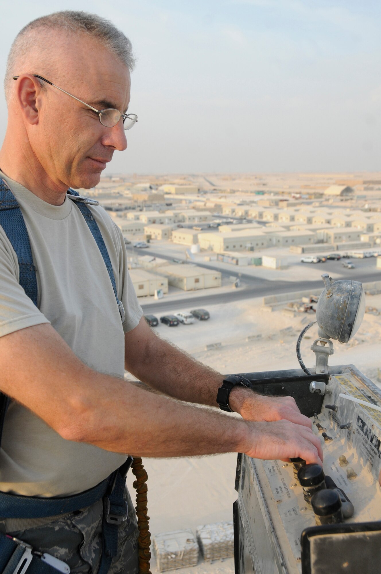 Master Sgt. Michel Senecal, superintendent of Air Terminal Operations assigned to the 8th Expeditionary Air Mobility Squadron, operates the condor to increase his height to finish installing the new flightline security camera Nov. 28, at an undisclosed air base in Southwest Asia. The new security camera will provide a higher view of the activities on the flightline. Sergeant Senecal, a native of Warwick, R.I., is deployed from North Kingston Air National Guard, R.I., in support of Operations Iraqi and Enduring Freedom and Joint Task Force-Horn of Africa. (U.S. Air Force photo by Staff Sgt. Darnell T. Cannady/Released)
