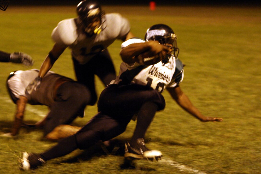 Joshua Brown, Combat Logistics Battalion 3 Warriors wide receiver, dodges a tackle while scrambling for yards during a 2008 Intramural Football League game at Bordelon Field Oct. 1.