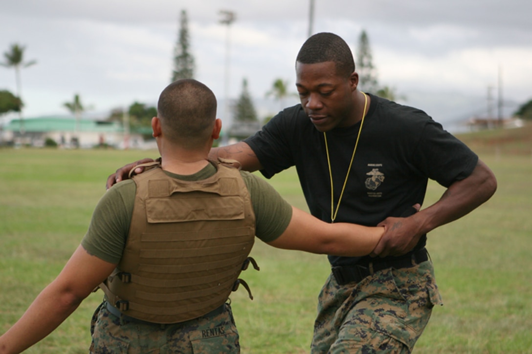 Sgt. LaVonne A. Watkins throws Sgt. Ismael Rentas Jr., financial management research anaylst, off balance with a leg sweep during a portion of the MCMAP green belt course here Oct. 1. Watkins is a MCMAP black belt instructor and the MarForPac electronic key management system alternate manager.