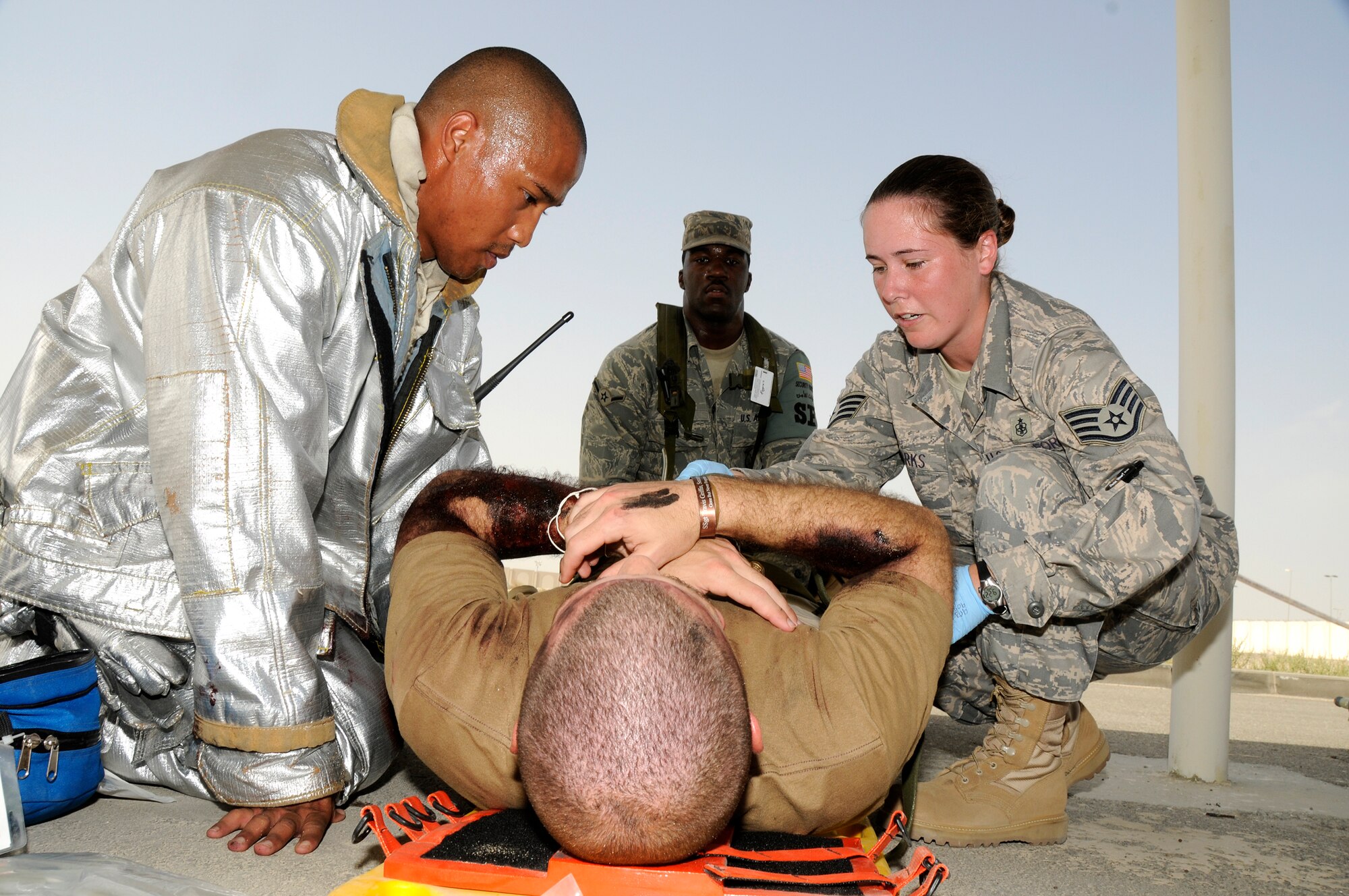 SOUTHWEST ASIA -- First responders take quick action to aid a simulated burn victim here Sept. 30. The 380th Air Expeditionary Wing exercise controllers have designed a variety of scenarios to aid in the wing's emergency preparedness. The exercises are designed to improve response times while following procedures. They are also enlisted to increase responders' knowledge of life-saving techniques and the ability to excel in the face of adversity. (U.S. Air Force photo/Tech. Sgt. Christopher A. Campbell)(released)  