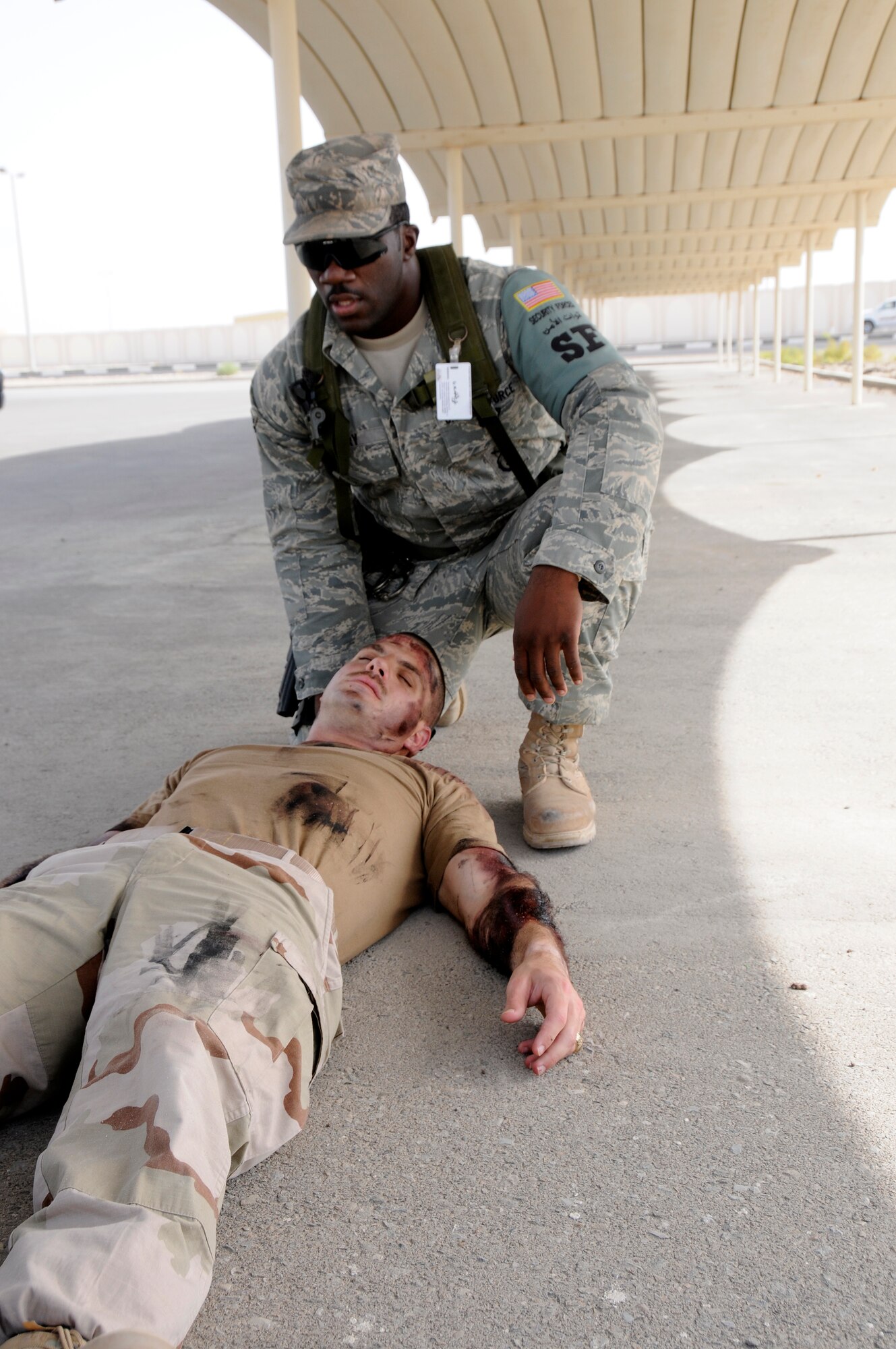 SOUTHWEST ASIA -- Airman Kenneth Perry from the 380th Expeditionary Security Forces Squadron renders aid to a simulated unconscious burn victim here Sept. 30. The burn victim is Capt. Kevin Eberhart from the 380th Air Expeditionary Wing. The base exercise controllers have designed a variety of scenarios to aid in the wing's emergency preparedness. The exercises are designed to improve response times while following procedures. They are also enlisted to increase responders' knowledge of life-saving techniques and the ability to excel in the face of adversity. Airman Perry, a native of Atlanta, Ga., is deployed from the 325th SFS Tyndall Air Force Base, Fla. Capt. Eberhart is from San Antonio, Texas. (U.S. Air Force photo/Tech. Sgt. Christopher A. Campbell)(released)  
