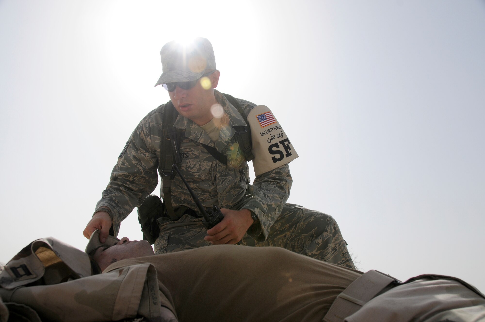 SOUTHWEST ASIA -- Tech. Sgt. Chad Roberts from the 380th Expeditionary Security Forces Squadron renders aid to a simulated unconscious burn victim here Sept. 30. The burn victim is Capt. Kevin Eberhart from the 380th Air Expeditionary Wing. The base exercise controllers have designed a variety of scenarios to aid in the wing's emergency preparedness. The exercises are designed to improve response times while following procedures. They are also enlisted to increase responders' knowledge of life-saving techniques and the ability to excel in the face of adversity. Sergeant Roberts, a native of Mansfield, Ohio., is deployed from the 88th SFS Wright-Patterson Air Force Base, Ohio. Capt. Eberhart's hometown is San Antonio, Texas. (U.S. Air Force photo/Tech. Sgt. Christopher A. Campbell)(released)  