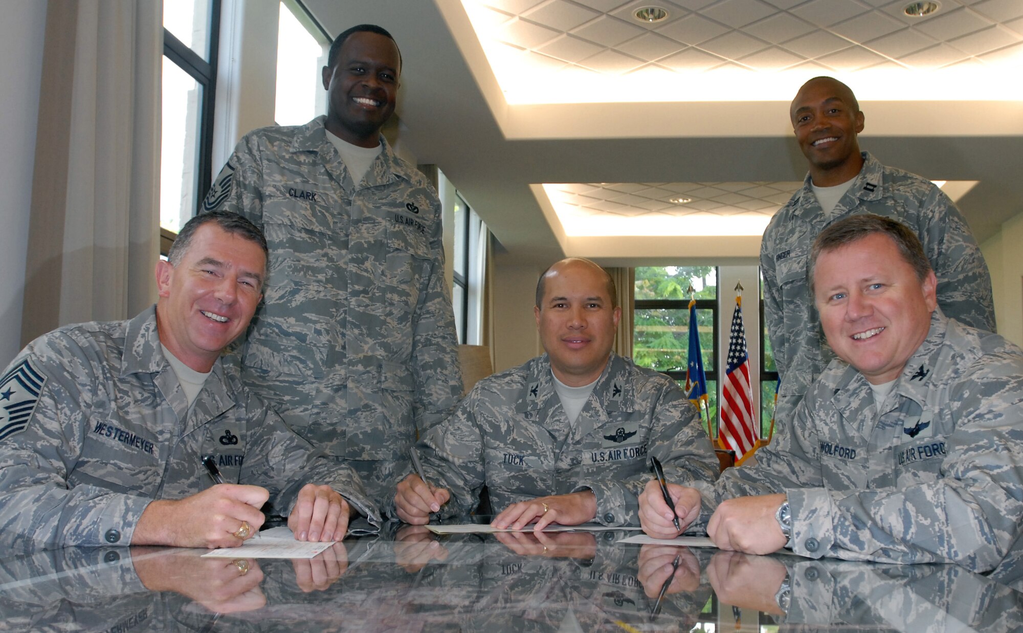 Wing leadership started their Air Force day off by signing Combined Federal Campaign donation cards Oct 1, as base CFC mangers, left, Master Sgt. Daniel Clark, 15th Civil Engineer Squadron and Capt. Joseph Ringer standby. The 15th Airlift Wing leadership from left to right:  Chief Master Sgt. Thomas Westermeyer, 15th AW command chief, Col. Giovanni Tuck, 15th AW commander and Col.  Dean Wolford, 15th AW vice commander.  Team Hickam’s goal during this year’s CFC "Because Someone You Know Needs Your Help" campaign is $287,000. Team Hickam members can contact their unit CFC representatives for information on making donations.  For more information about this year’s campaign, visit the local website http://www.cfc-hawaii.org/. (U.S. Air Force Photo/Master Sgt. Robert Burgess)