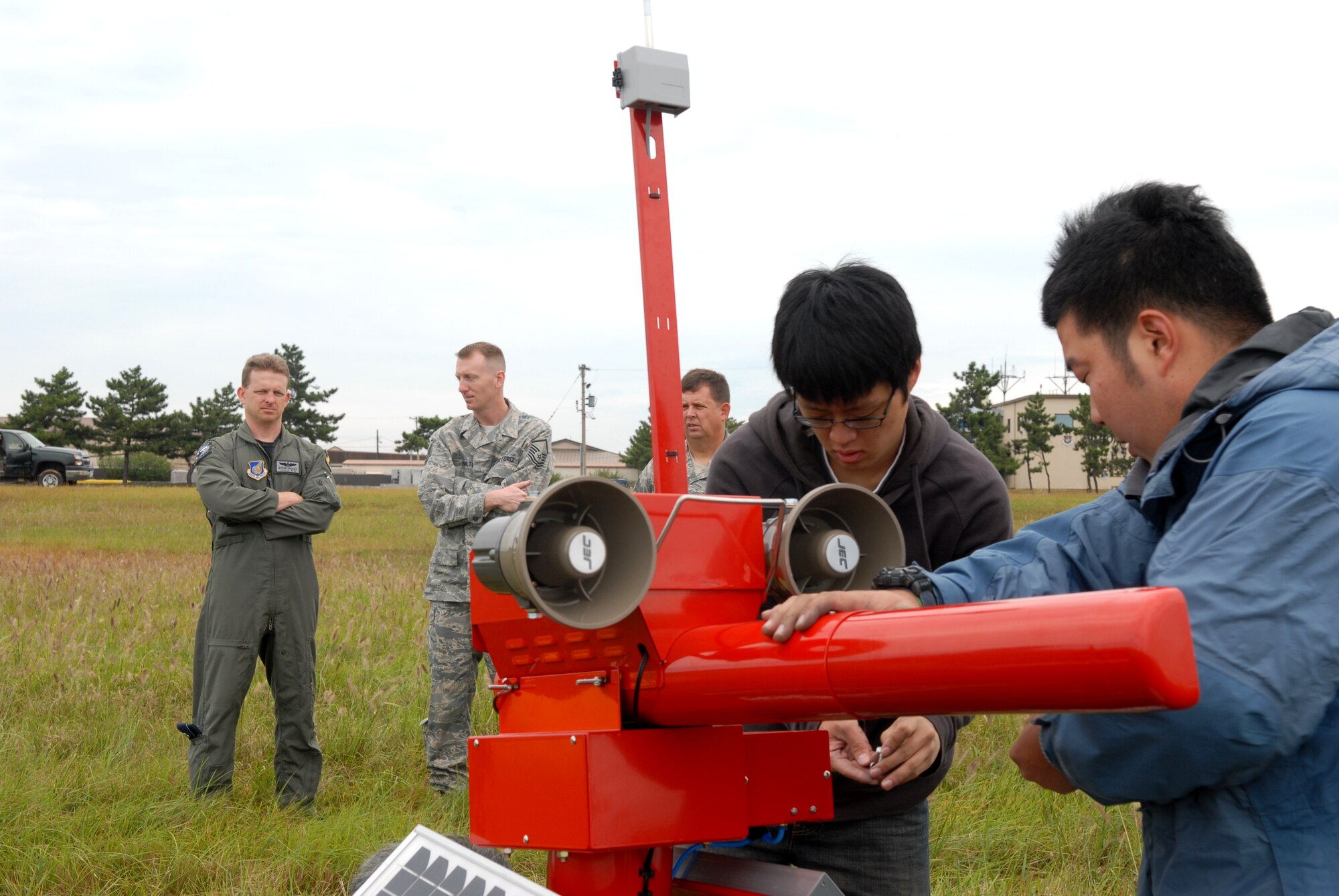 KUNSAN AIR BASE, Republic of Korea -- Members of a bird cannon installation crew install the system while Lt. Col. Stephen Hickey, 8th Fighter Wing Safety chief, Master Sgt. Guy Hamilton, 8th Fighter Wing Flight Safety NCOIC , and Master Sgt. Richard Cleveland, 8th Fighter Wing Flight Safety, observe here Sep. 29. The bird cannons are being installed as part of the Bird Wildlife Aircraft Strike Hazard program, which aims to keep the flight line and a variety of aircraft safe from bird hazards.(U.S. Air Force photo by Senior Airman Angela Ruiz)