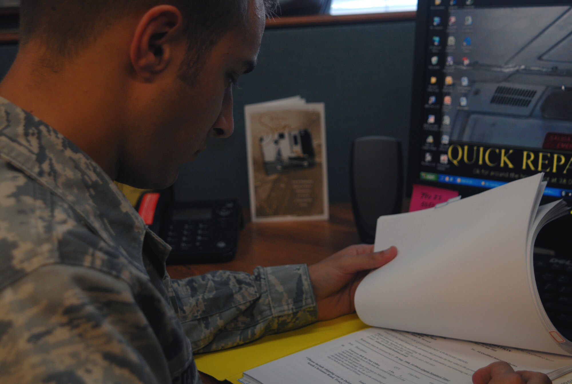 Airman 1st Class Adam Steward, an 18th Contracting Squadron contracting specialist, looks over a contracting document for fiscal year 2008 as the year draws to a close Sept. 30.  (U.S. Air Force photo/Staff Sgt. Christopher Marasky)