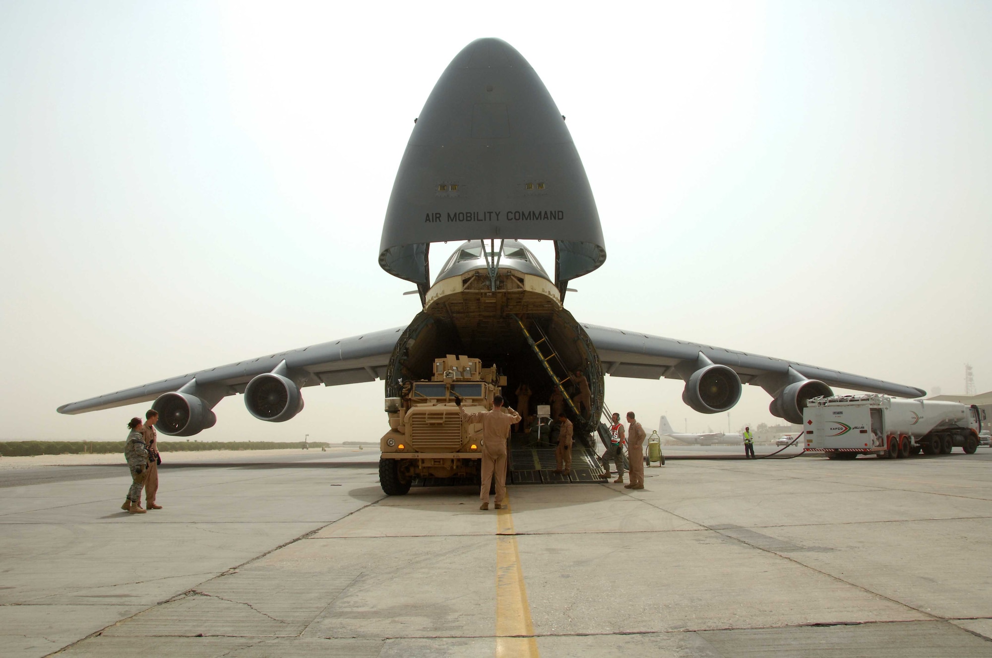 Travis members unload the 10,000th mine-resistant, ambush-protected vehicle from a C-5 Galaxy in Southwest Asia recently. The delivery was a milestone for Air Mobility Command Airmen who have worked to deliver the vehicles since their introduction in 2007. (U.S. Air Force photo)
