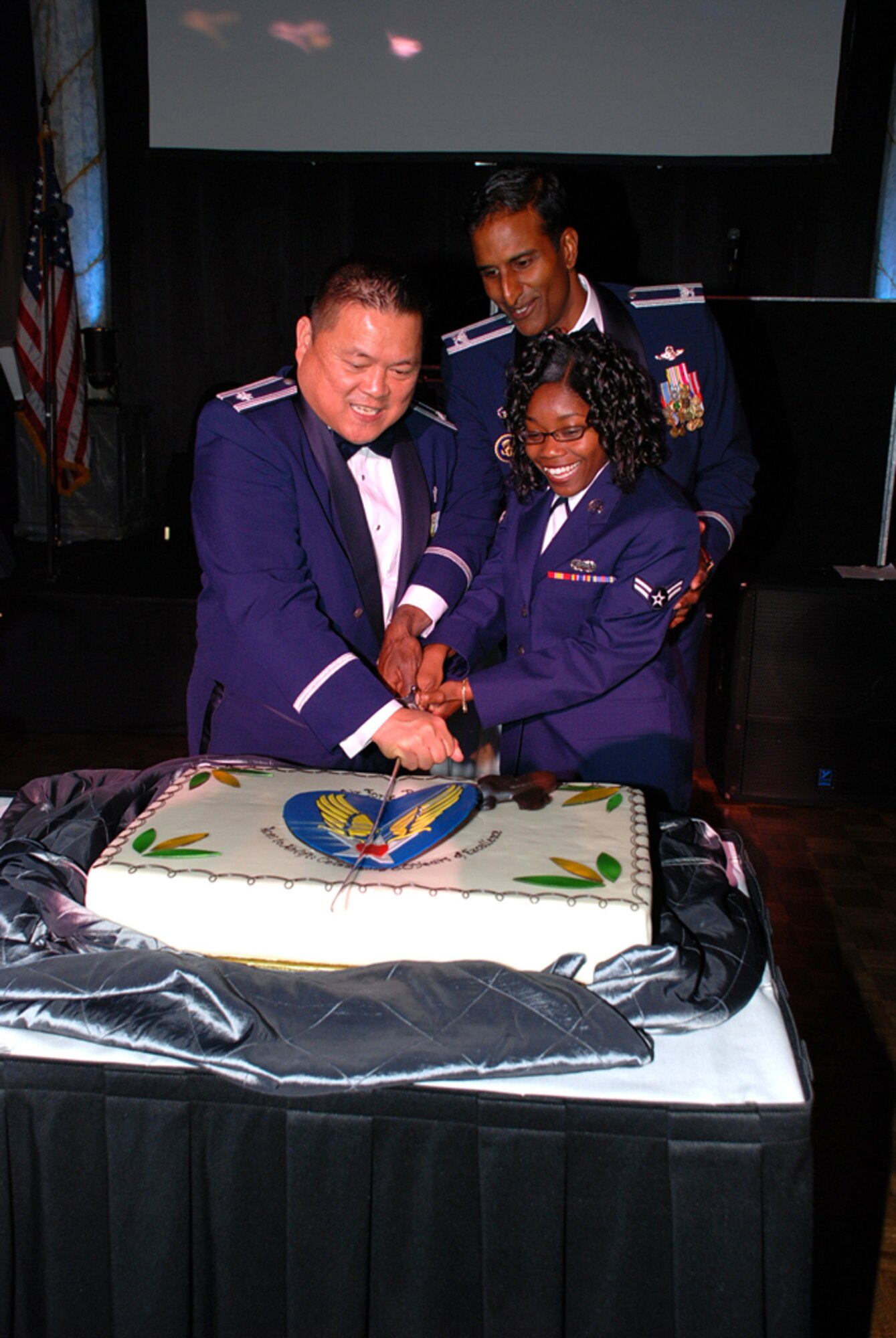 Col. Balan Ayyar (center), 305th Air Mobility commander, cuts the McGuire Air Force Ball birthday cake with Lt. Col. Joseph Lim, 305th AMW, who had the most time in service, and Airman 1st Class Amani Phillips, 305th Communications Squadron, who had the least time in service, during the ball Sept. 26 at the Trump Plaza in Atlantic City, N.J. Several hundred McGuire Airmen attended the ball to celebrate 60 years of McGuire AFB and 61 years of the Air Force. (U.S. Air Force photo/Capt. Darrick Lee) 
