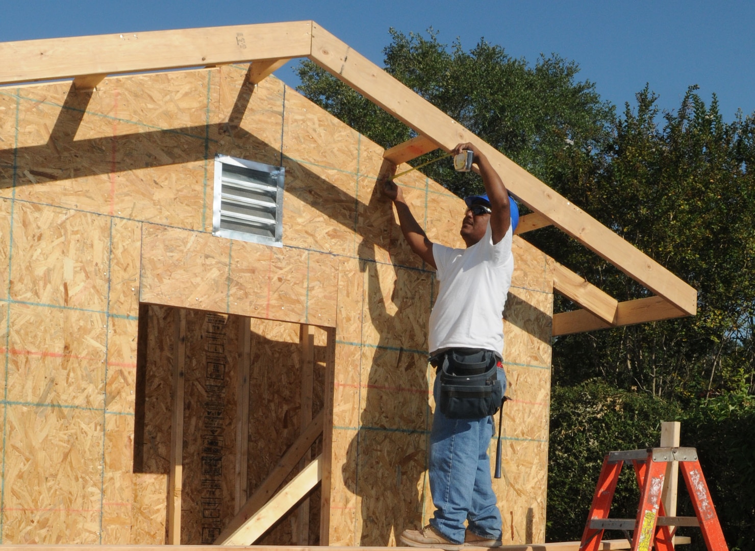 Mondo Rodriguez, a subcontractor for Pinnacle/Hunt, take a mesaurement on a carport being built in base housing Oct. 1. (U.S. Air Force photo by Rich McFadden)