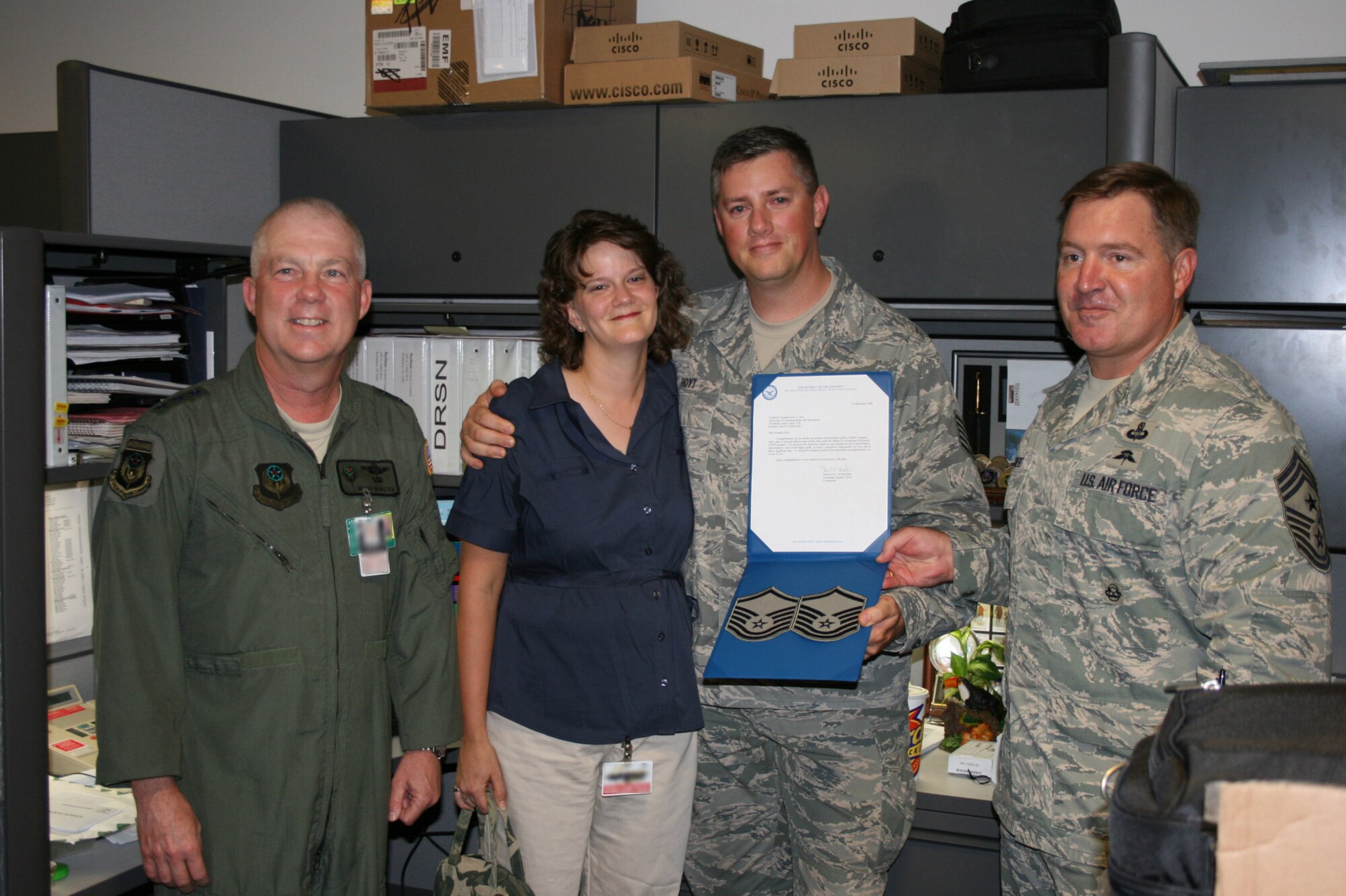 Air Force Special Operations Command's newest senior noncommissioned officer, Master Sgt. Scott Hoyt, proudly displays his new stripes after he is congratulated by Lt. Gen. Donny Wurster (left), AFSOC commander, his wife, Angela, and Command Chief Master Sgt. Michael Gilbert (right). Sergeant Hoyt was promoted under the Stripes for Exceptional Performers, or STEP, program.(courtesy photo illustration).