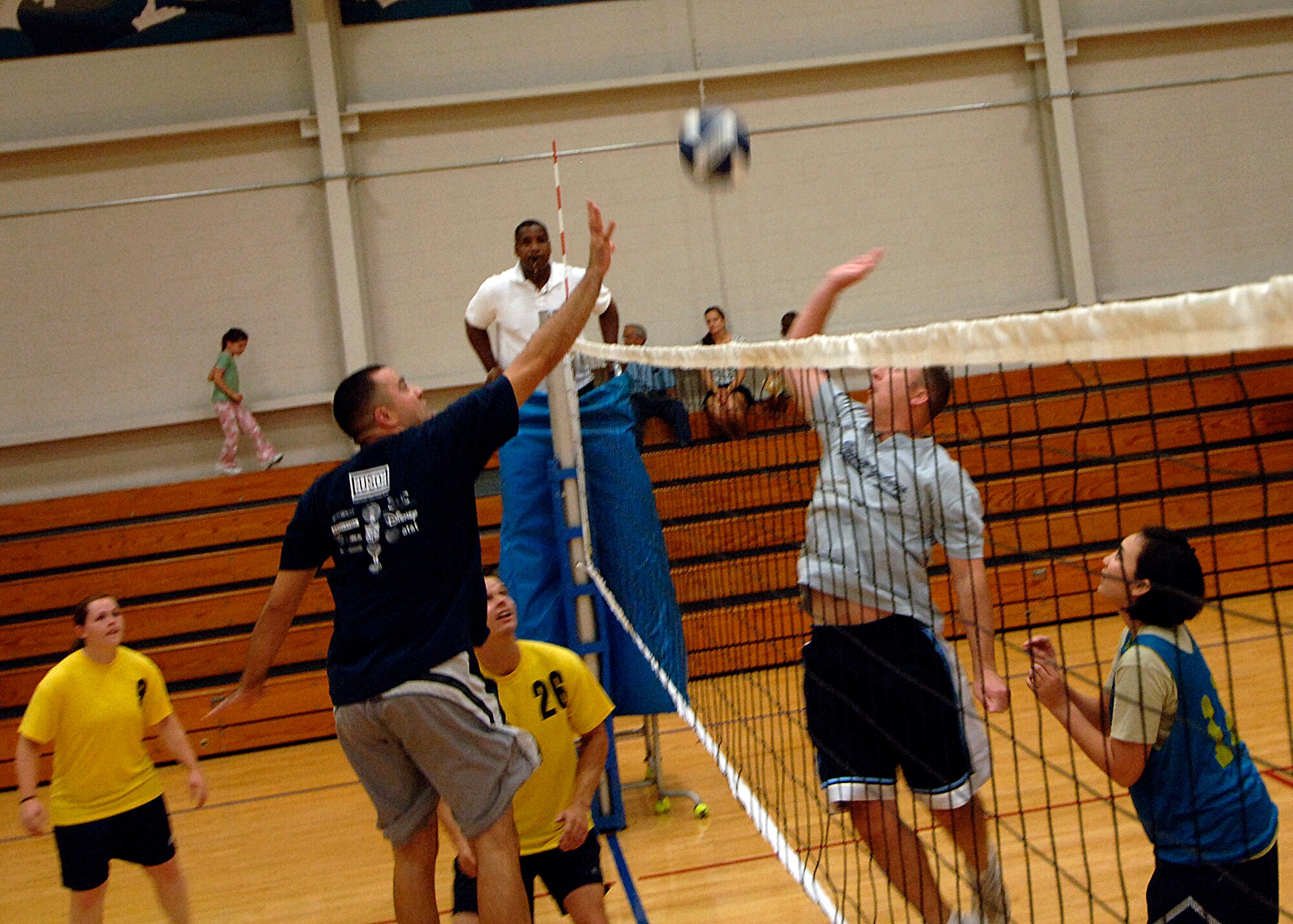 Orlando Rodriguez (left) and Chris Sinclair (right) jump towards the volley ball to spike at one another's side of the court at the base fitness center Sept. 30. Rodriguez is with the 437th Aerial port squadron and Sinclair is with the 437th Communications squadron. APS defeated COM 25-17 in two out of three games. (U.S. Air Force photo/Airman 1st Class Timothy Taylor)
