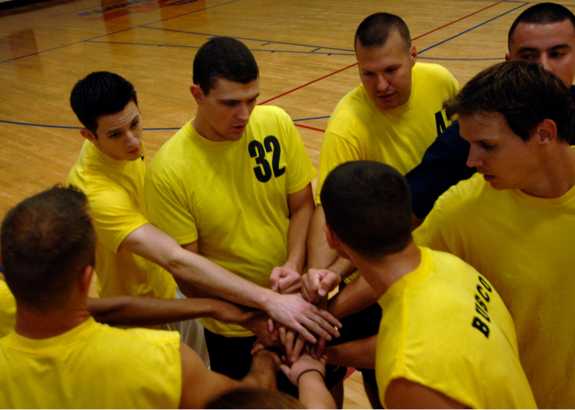 Team APS huddles for a pep talk before the game begins at the base fitness center Sept. 30.  APS defeated COM 25-17 in two out of three games. (U.S. Air Force photo/Airman 1st Class Timothy Taylor)
